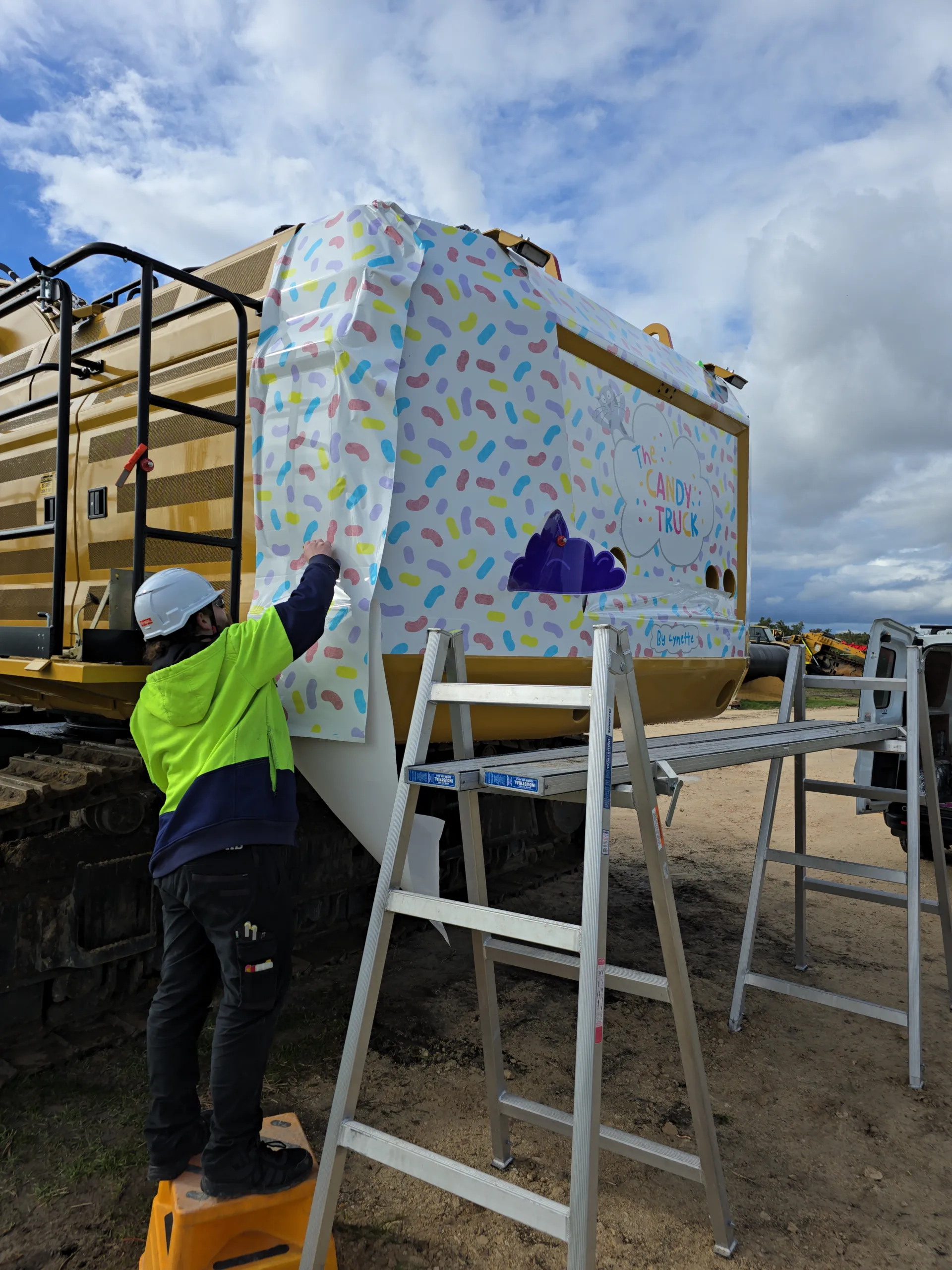 Portrait view of excavator graphics being fitted