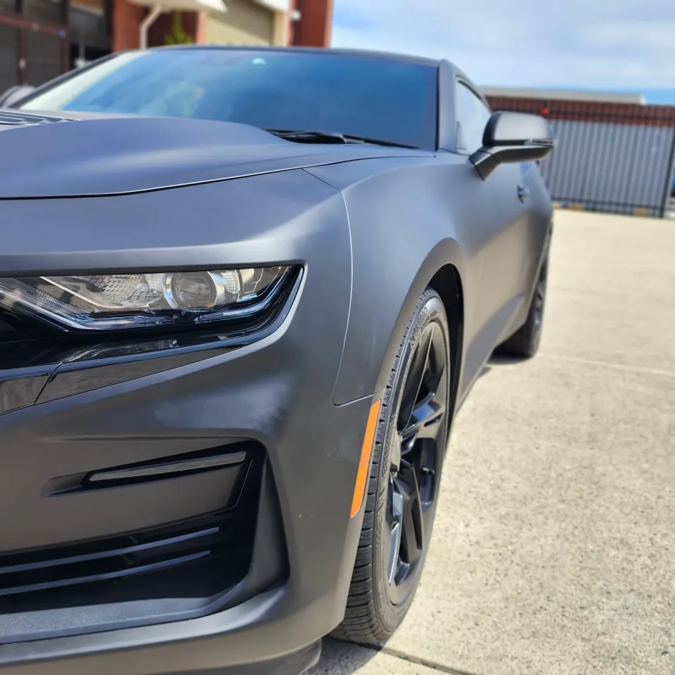 Matte Camaro SS front corner showing its grille badge, headlight and bumper