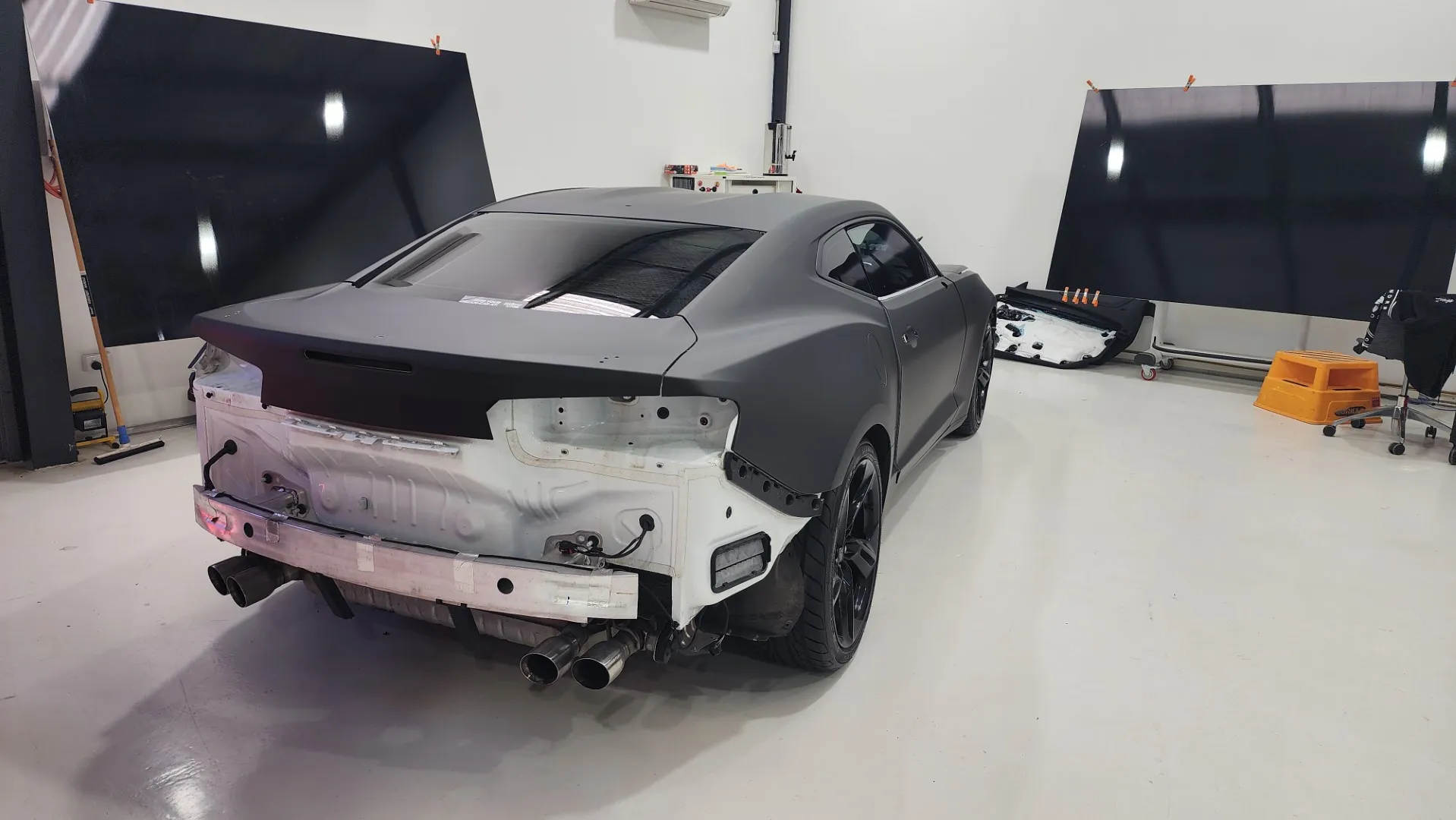 Matte black Chevrolet Camaro during wrapping with its rear bumper removed