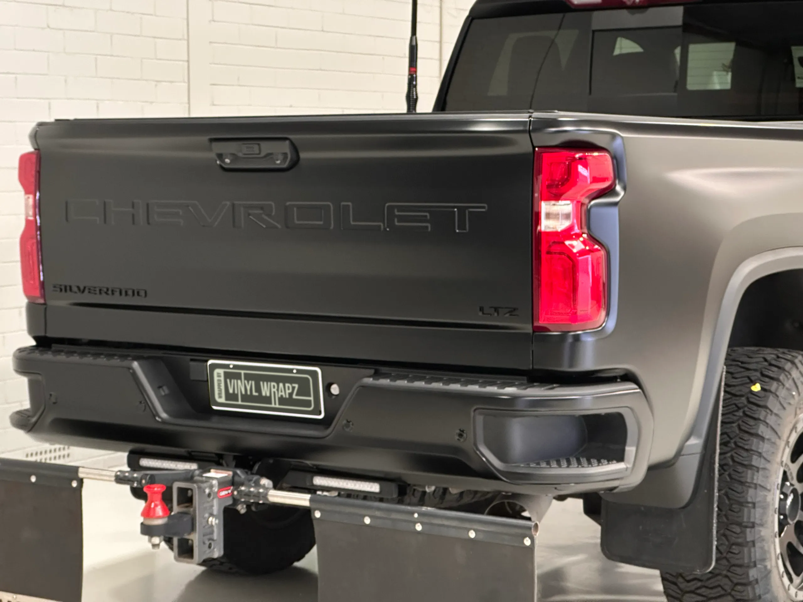 Matte black Chevrolet Silverado tailgate with LTZ lettering, rear lights and a heavy-duty tow hitch