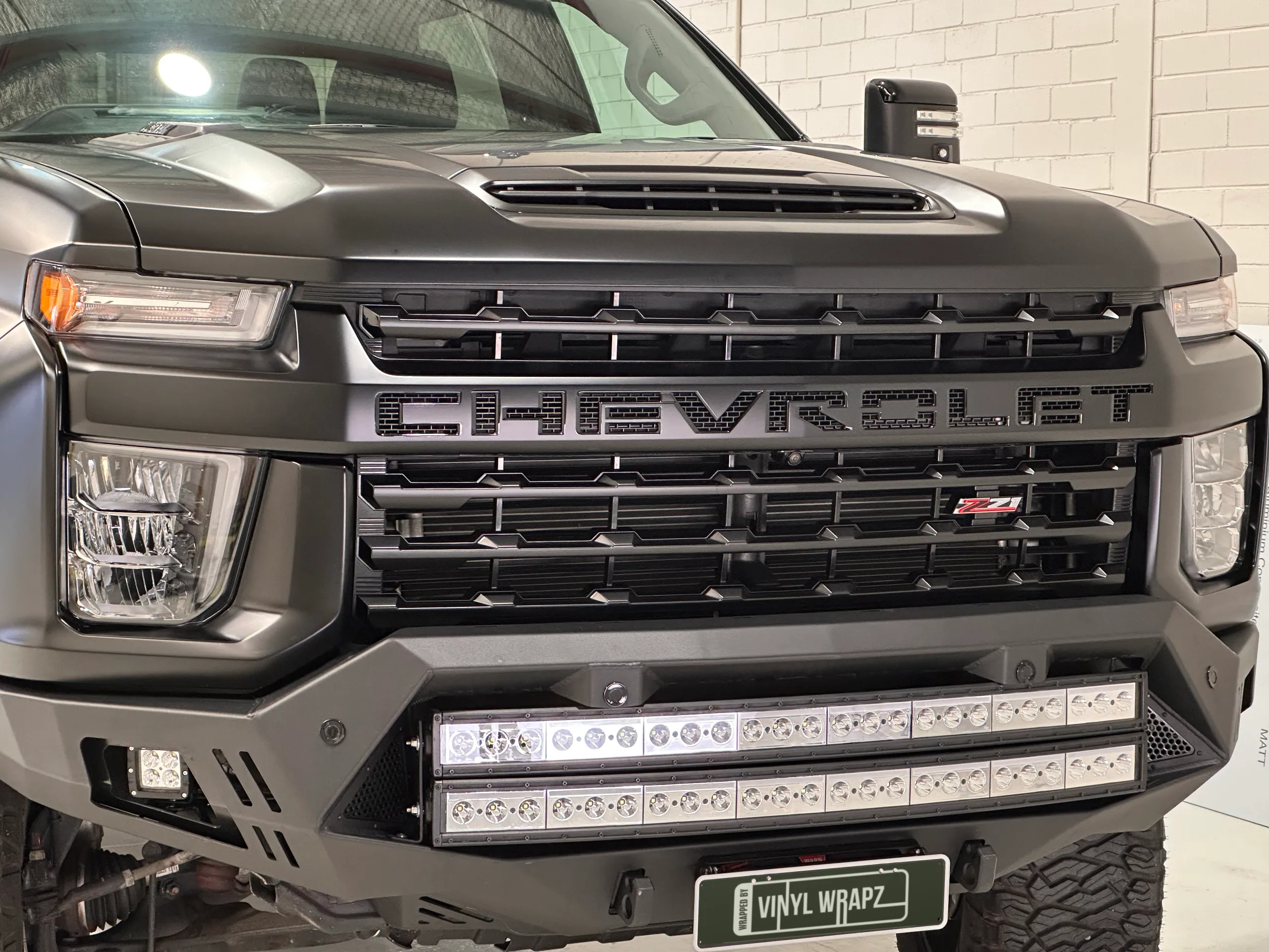 Chevrolet Silverado grille and matte black bonnet above twin light bars in the front bumper