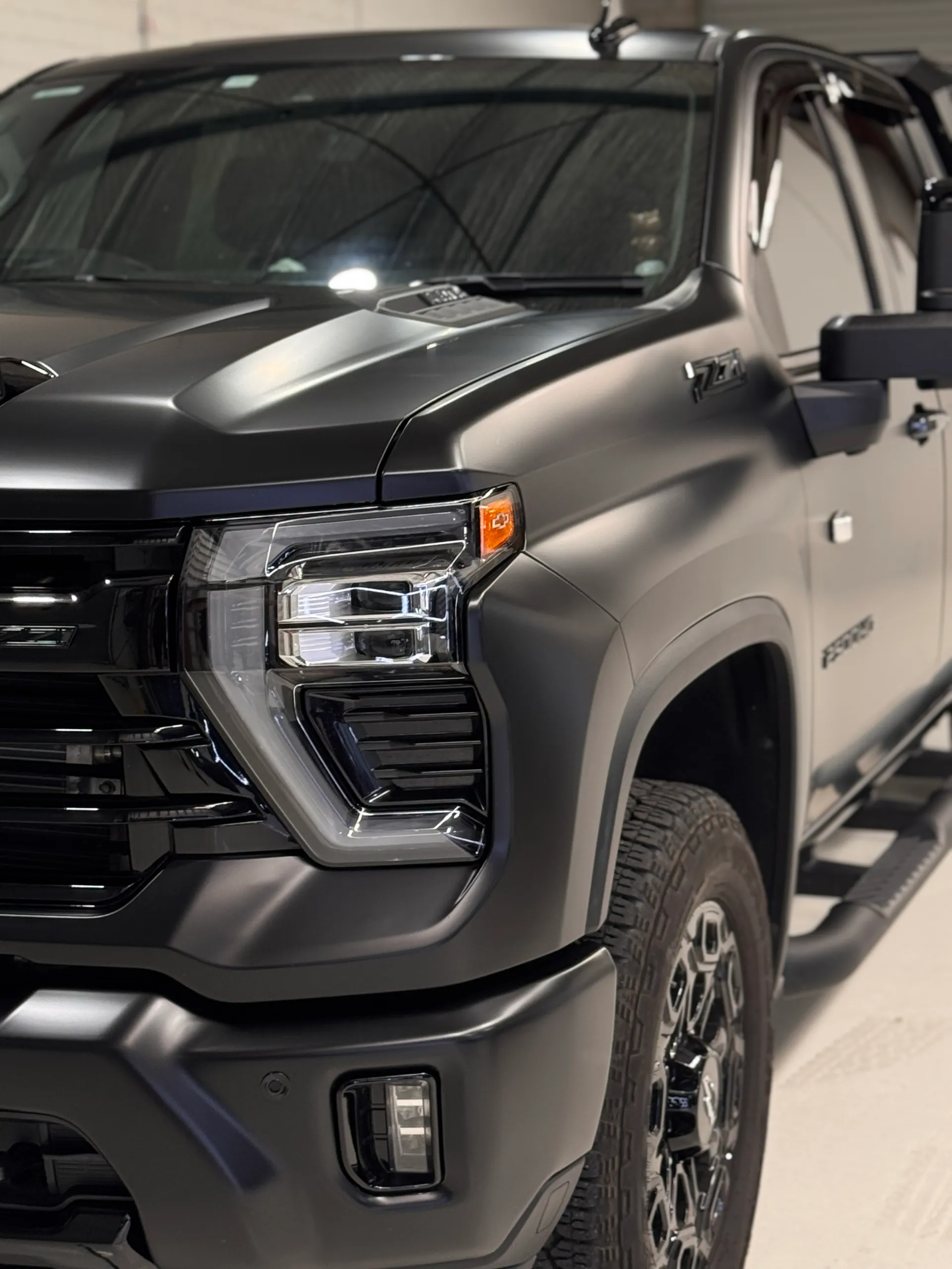 Matte Silverado front corner showing the headlight, guard and front wheel