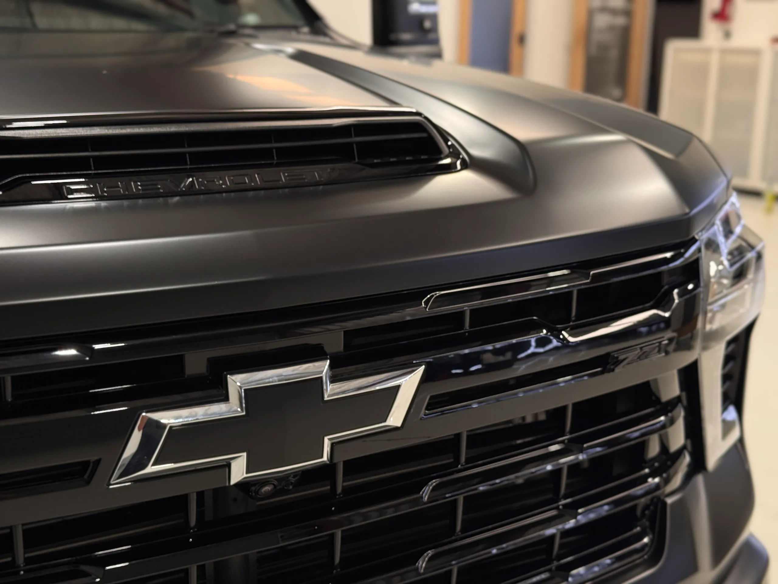 Chevrolet bowtie badge on the gloss black grille beneath the matte bonnet