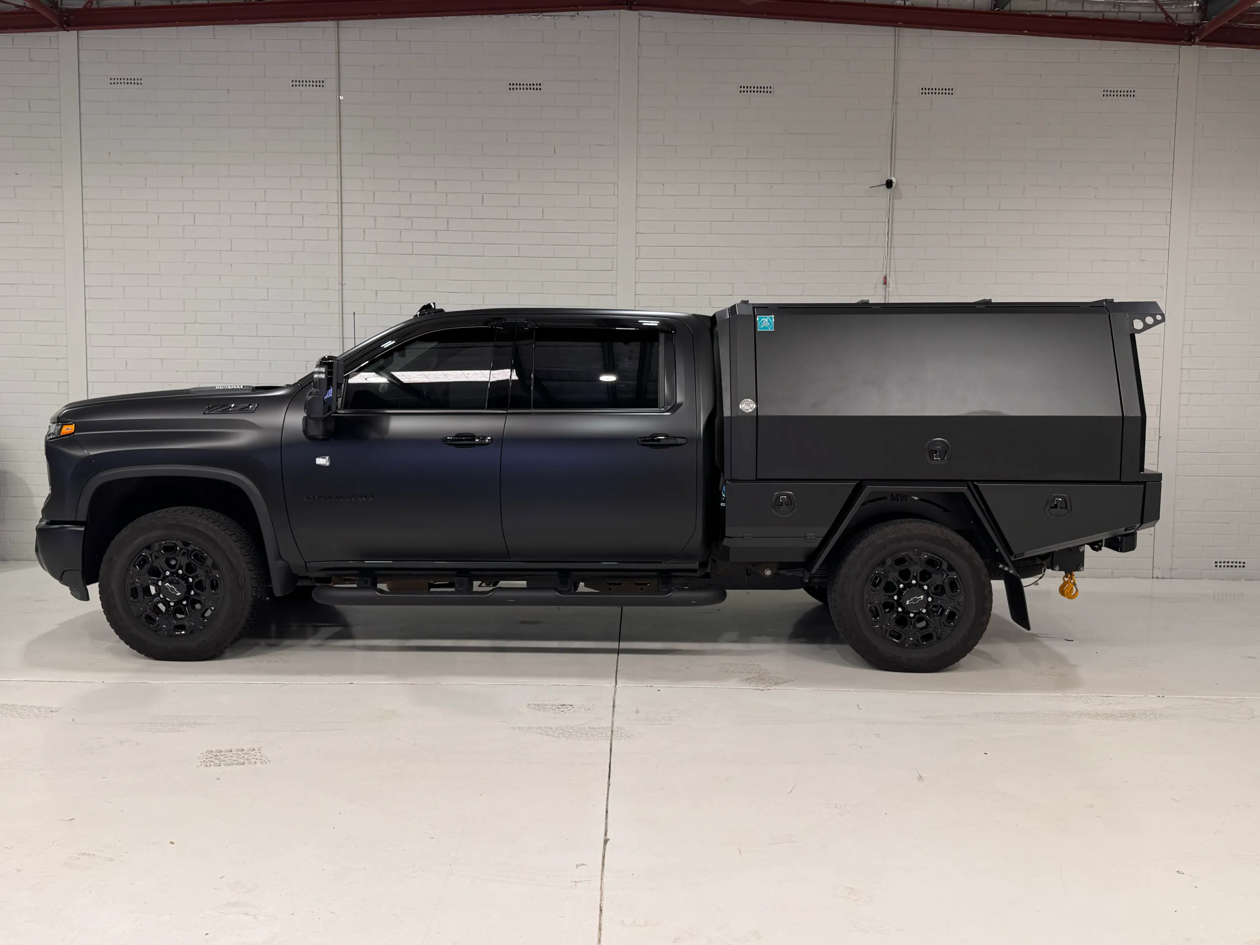 Side profile of the matte dark grey Silverado 2500 HD with a matching touring canopy