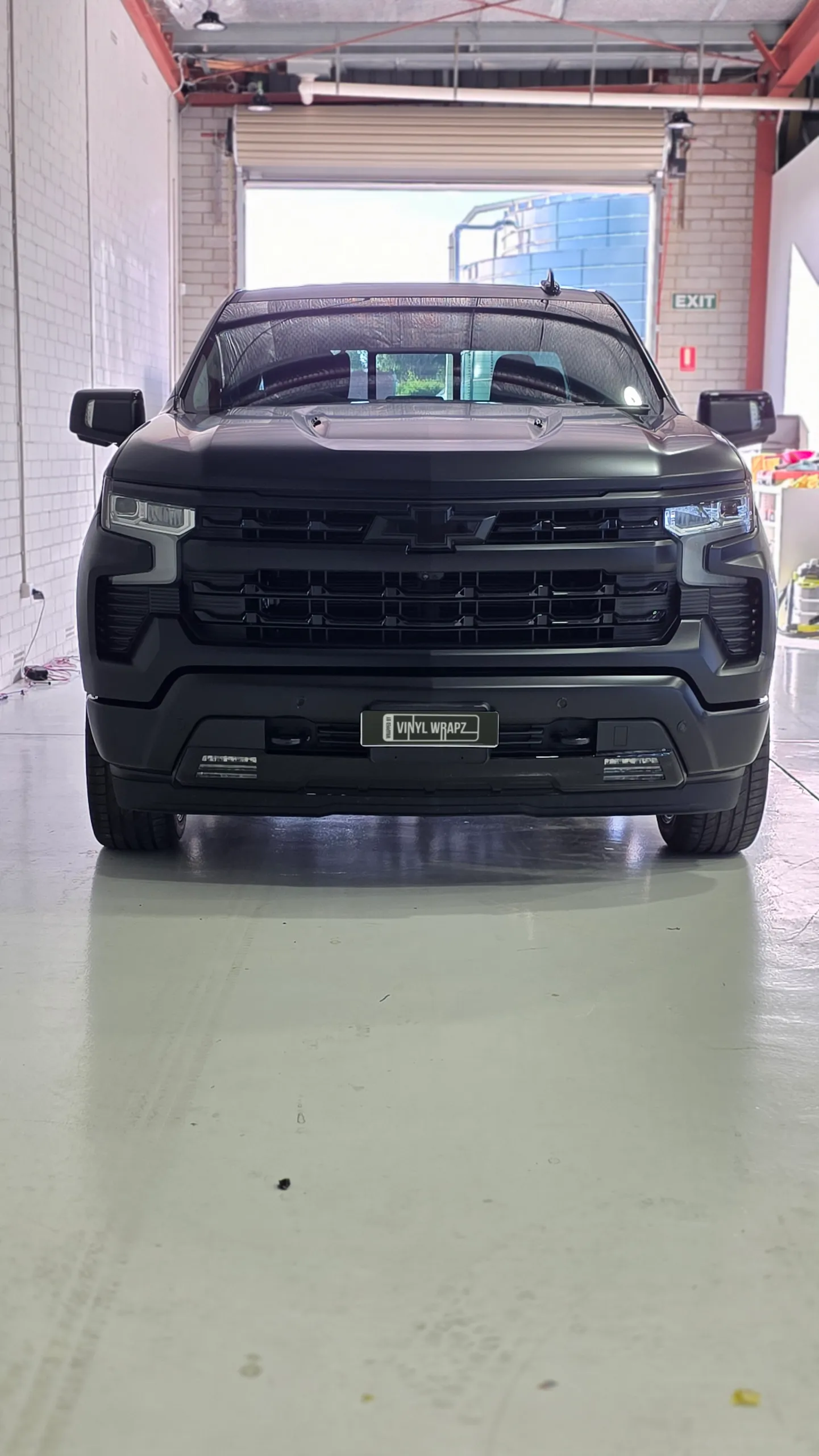 Front view of the satin black Chevrolet Silverado inside the workshop