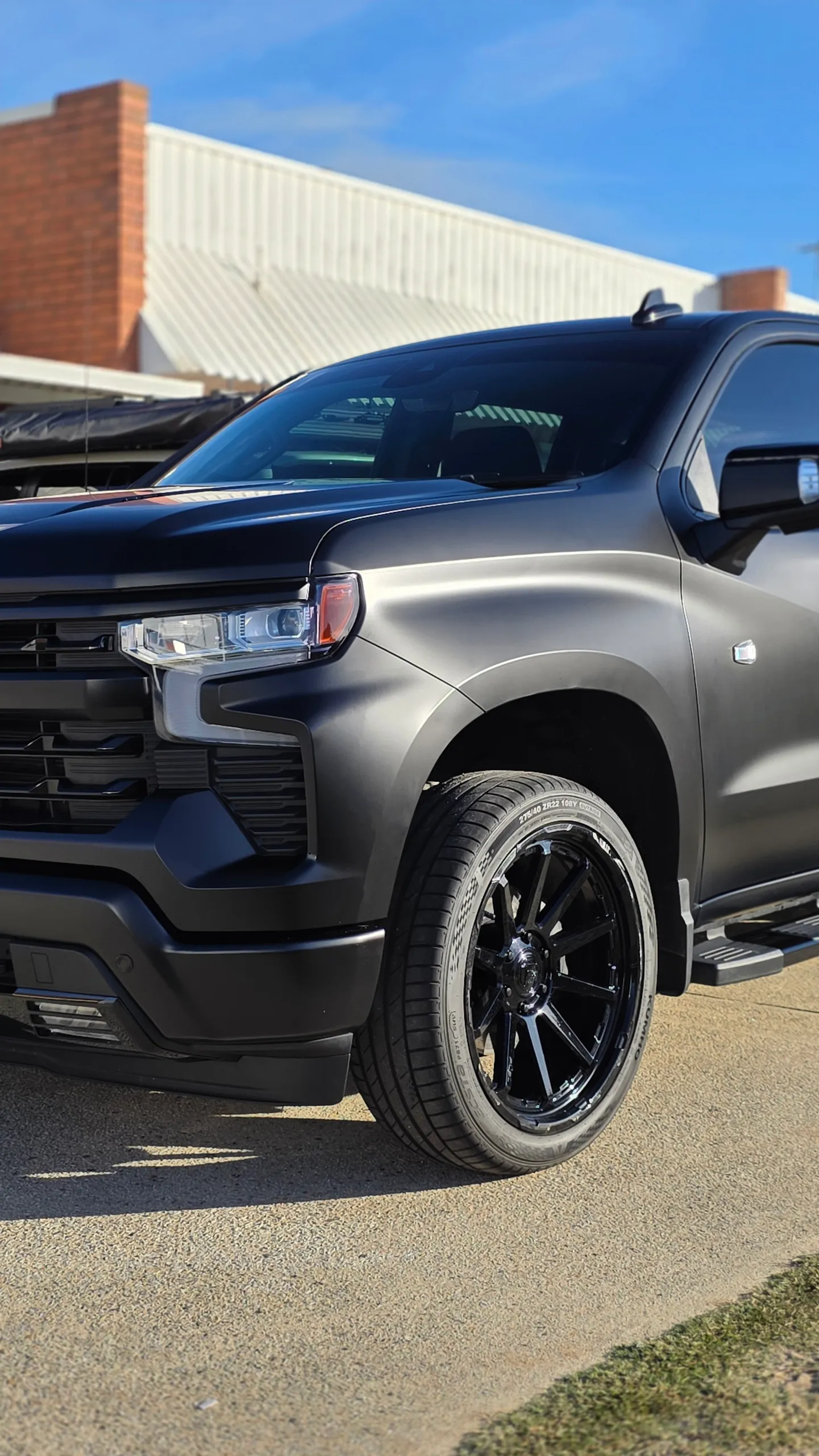 Satin black Chevrolet Silverado headlight, front guard and black wheel outdoors