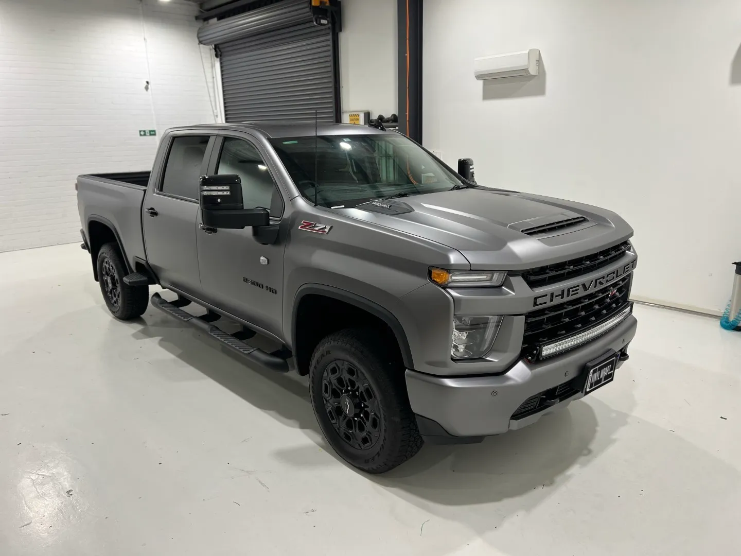 Matte anthracite Chevrolet Silverado front quarter and side in the workshop