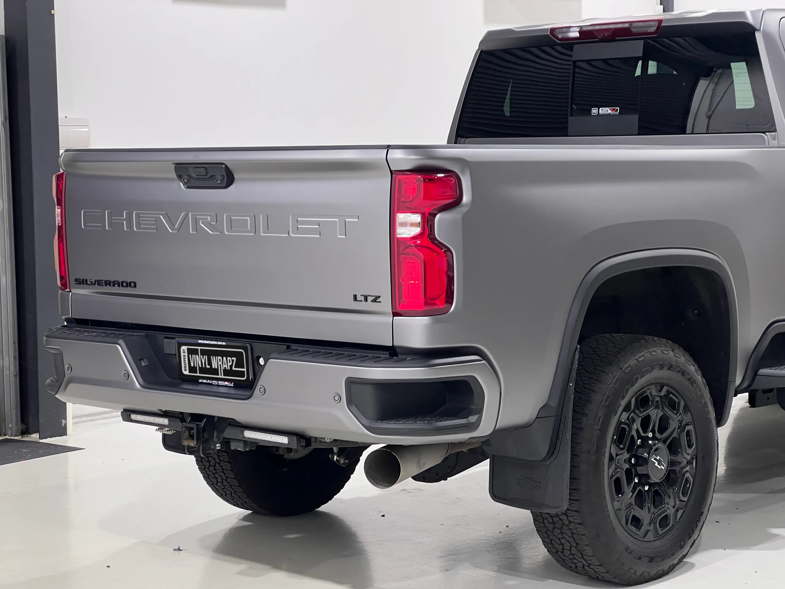 Matte anthracite Chevrolet Silverado rear quarter with tailgate and black wheels