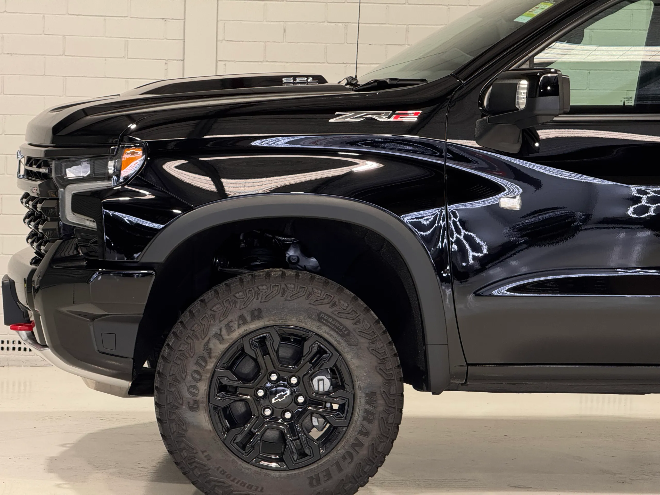 Chevrolet Silverado ZR2 front guard and wheel beneath gloss black bodywork