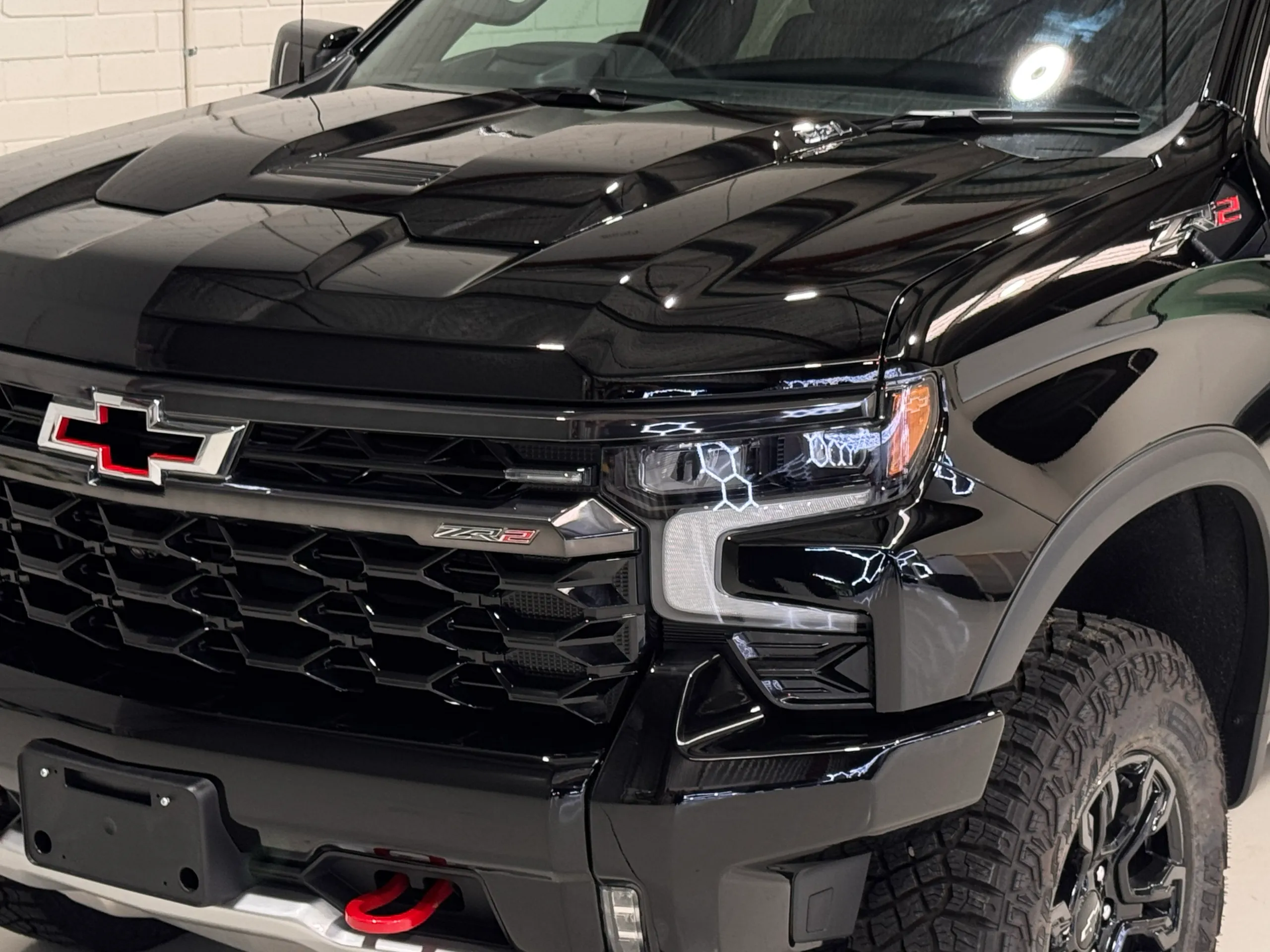 Gloss black Silverado bonnet and grille with the Chevrolet badge and red tow hooks