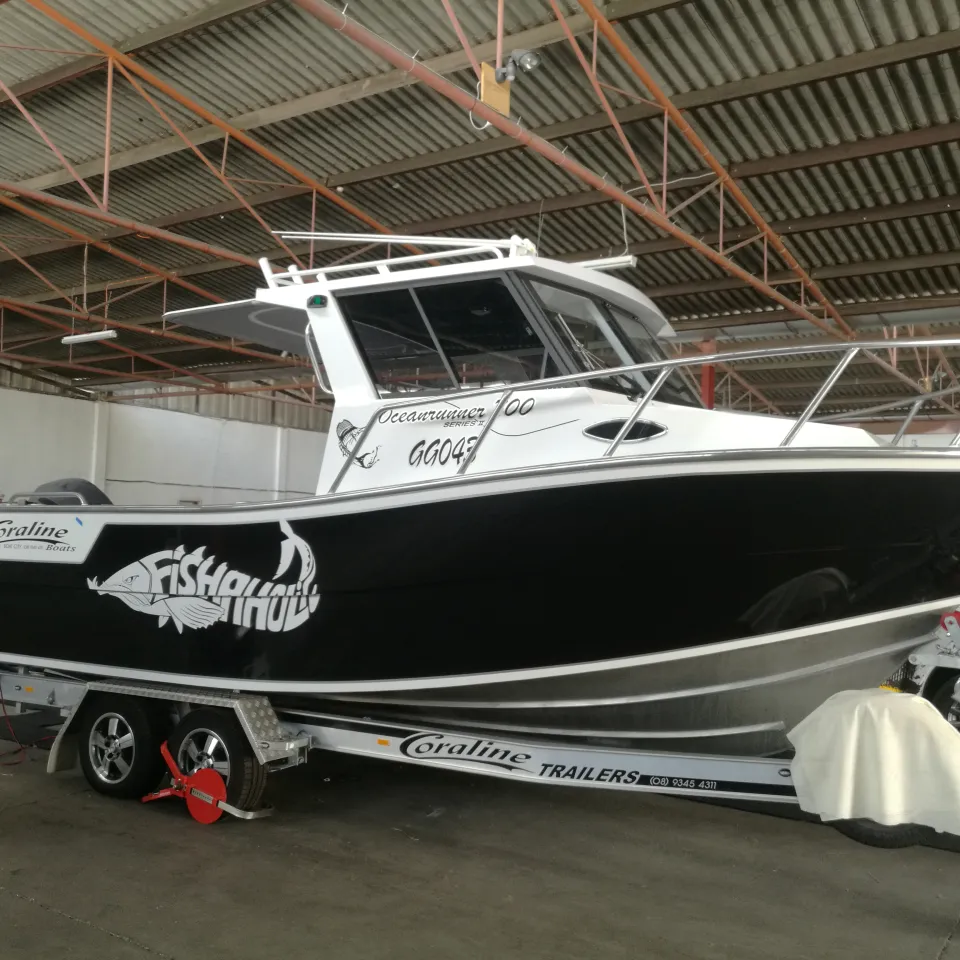 Coraline fishing boat on its trailer with a glossy black hull and white Fishaholic graphics