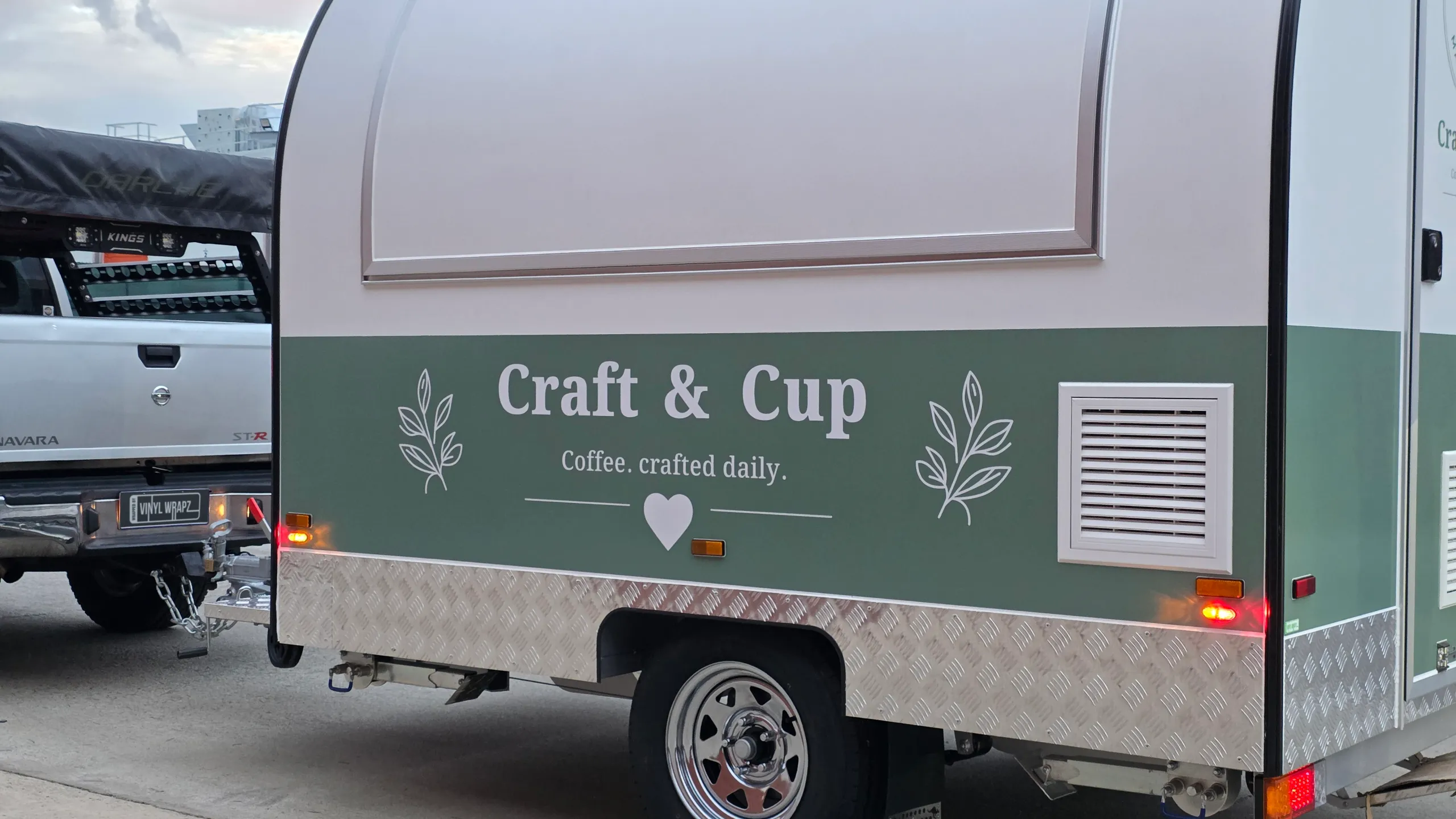 Craft and Cup branding below the closed serving hatch on a sage green and white coffee trailer