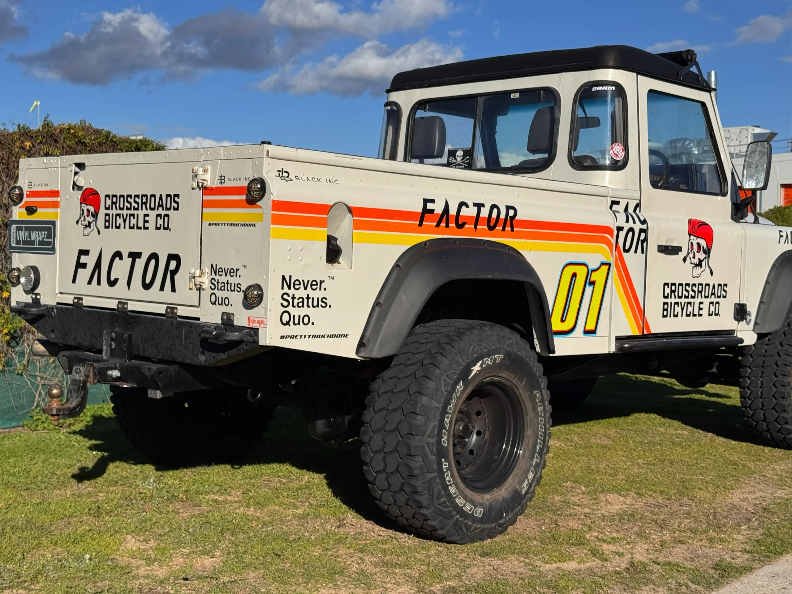 Rear-quarter view of the Defender ute showing Crossroads Bicycle Co graphics on its tailgate and sides