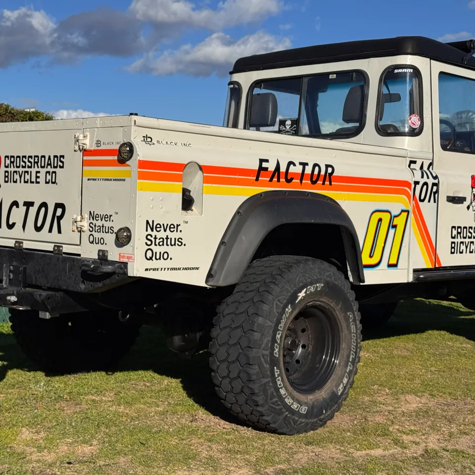 Rear-quarter view of the Defender ute showing Crossroads Bicycle Co graphics on its tailgate and sides