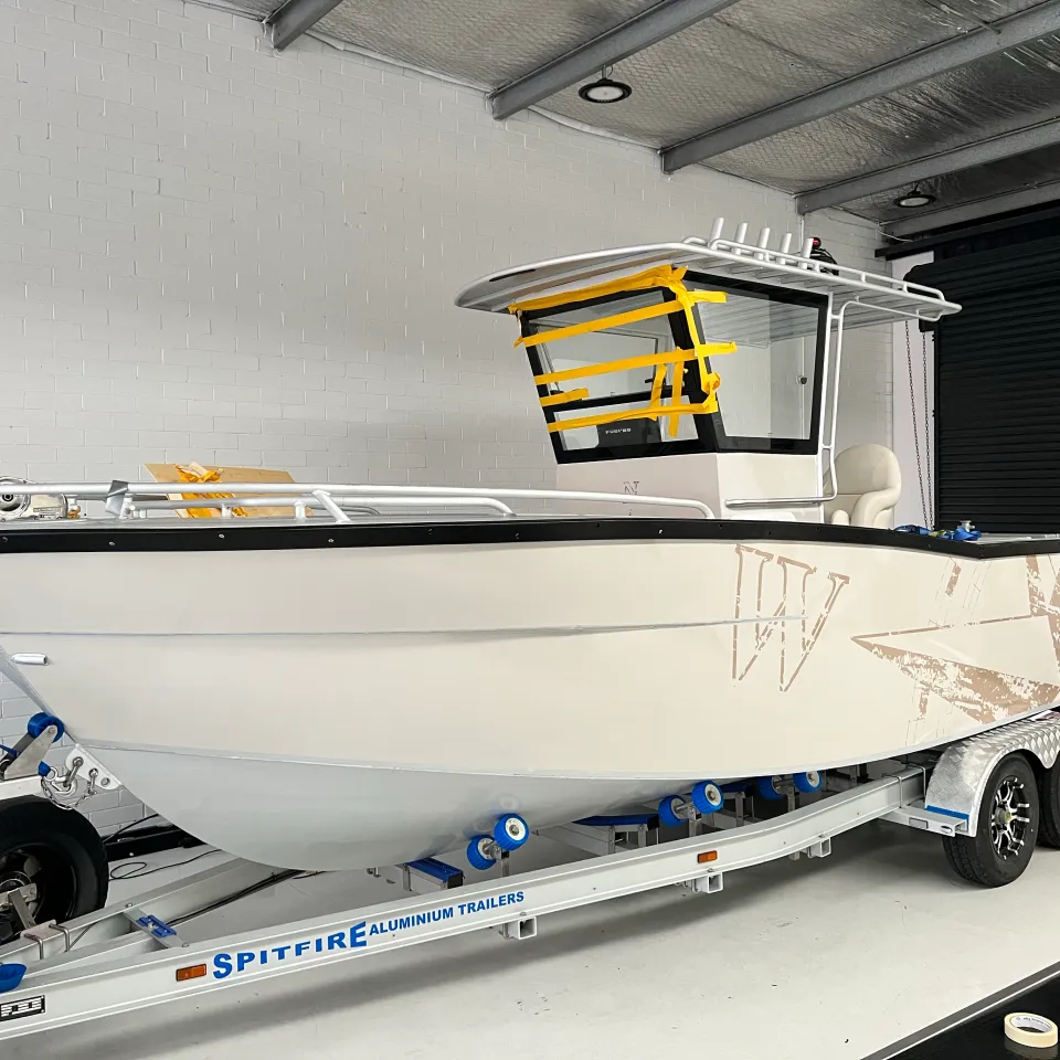 Cream and brown compass graphics fitted to the boat hull with its windscreen still masked
