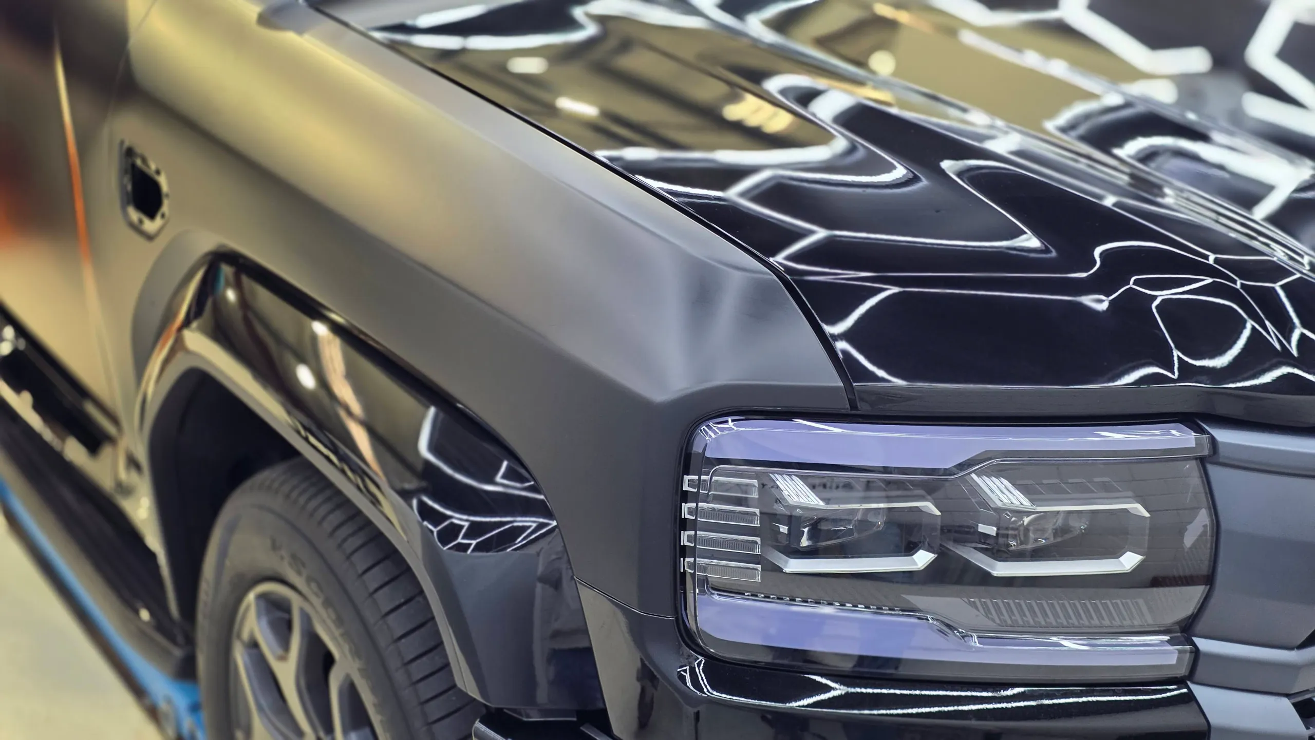 Denza B5 headlight and satin grey guard beside a gloss bonnet during conversion