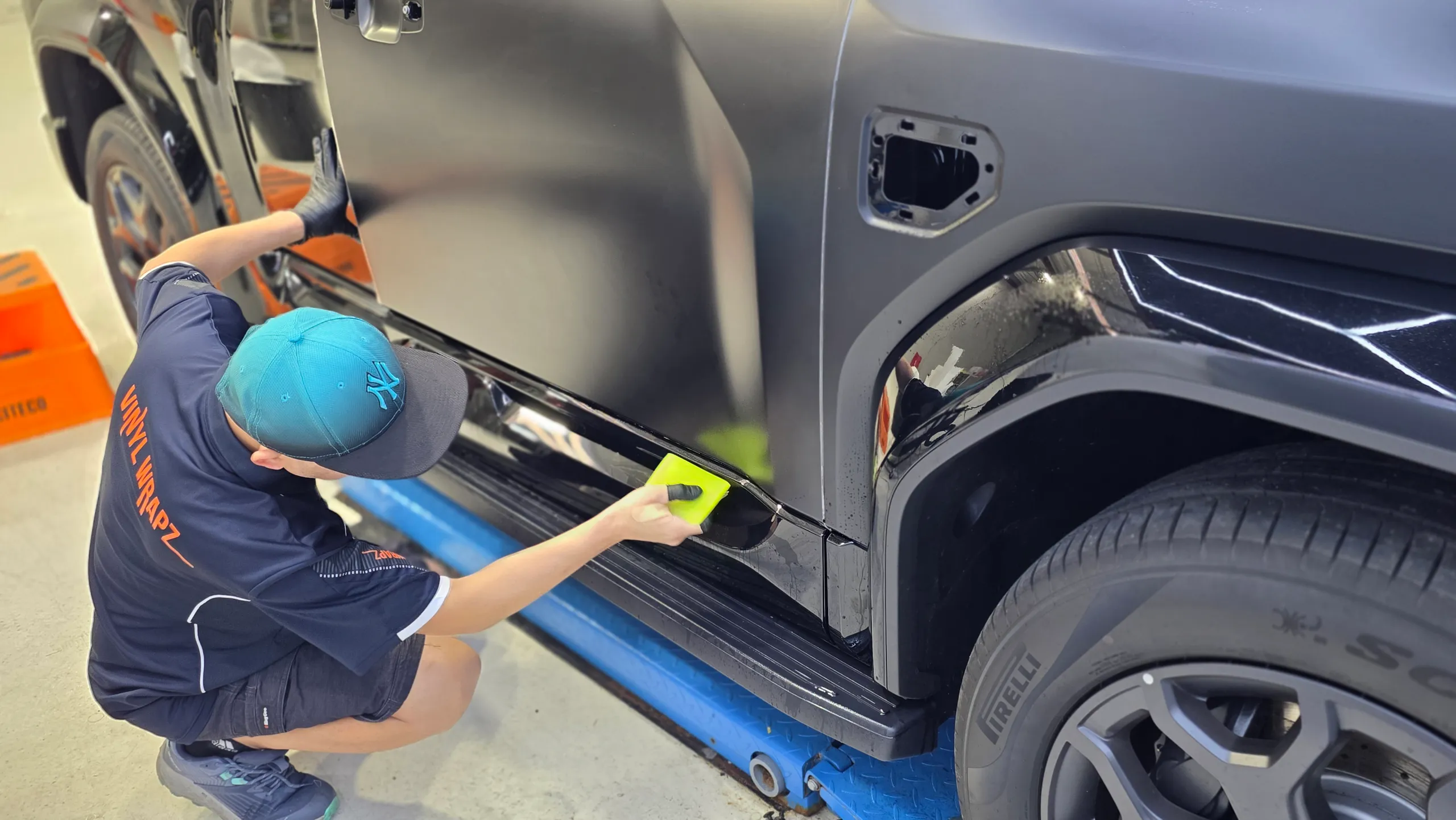 Installer smoothing film on the Denza B5 side panels with trim removed