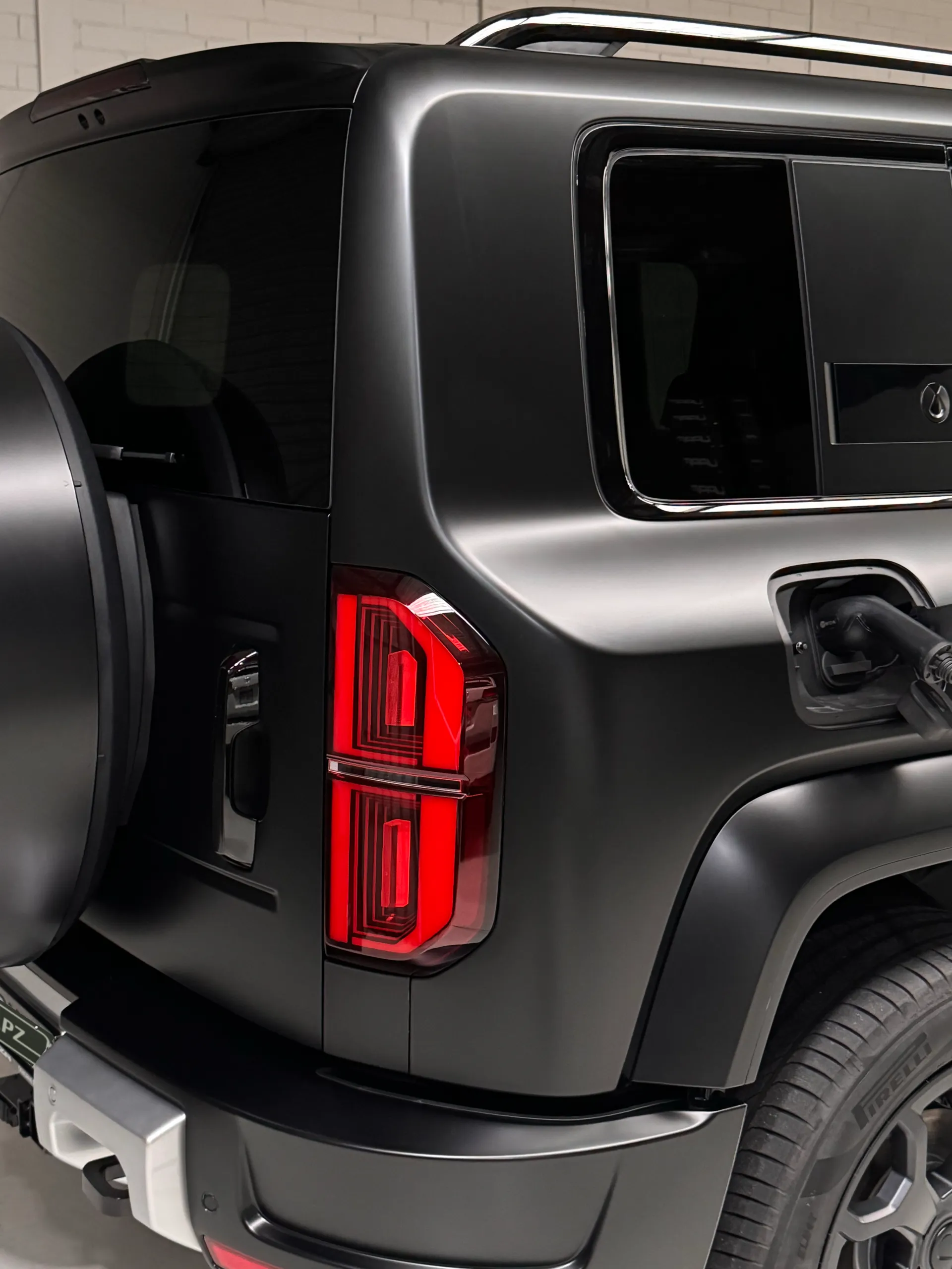 Denza B5 rear light and spare wheel cover beside its connected charging cable