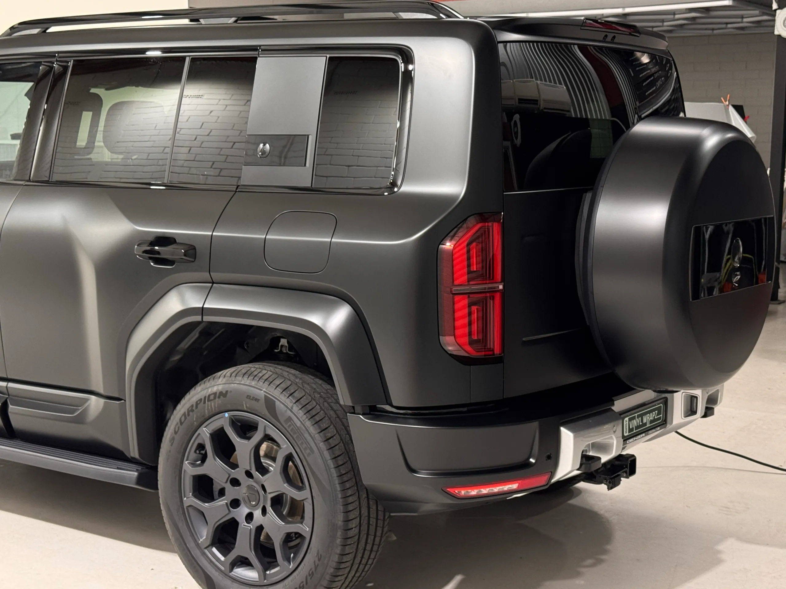 Denza B5 rear quarter, spare wheel cover and rear light inside the workshop