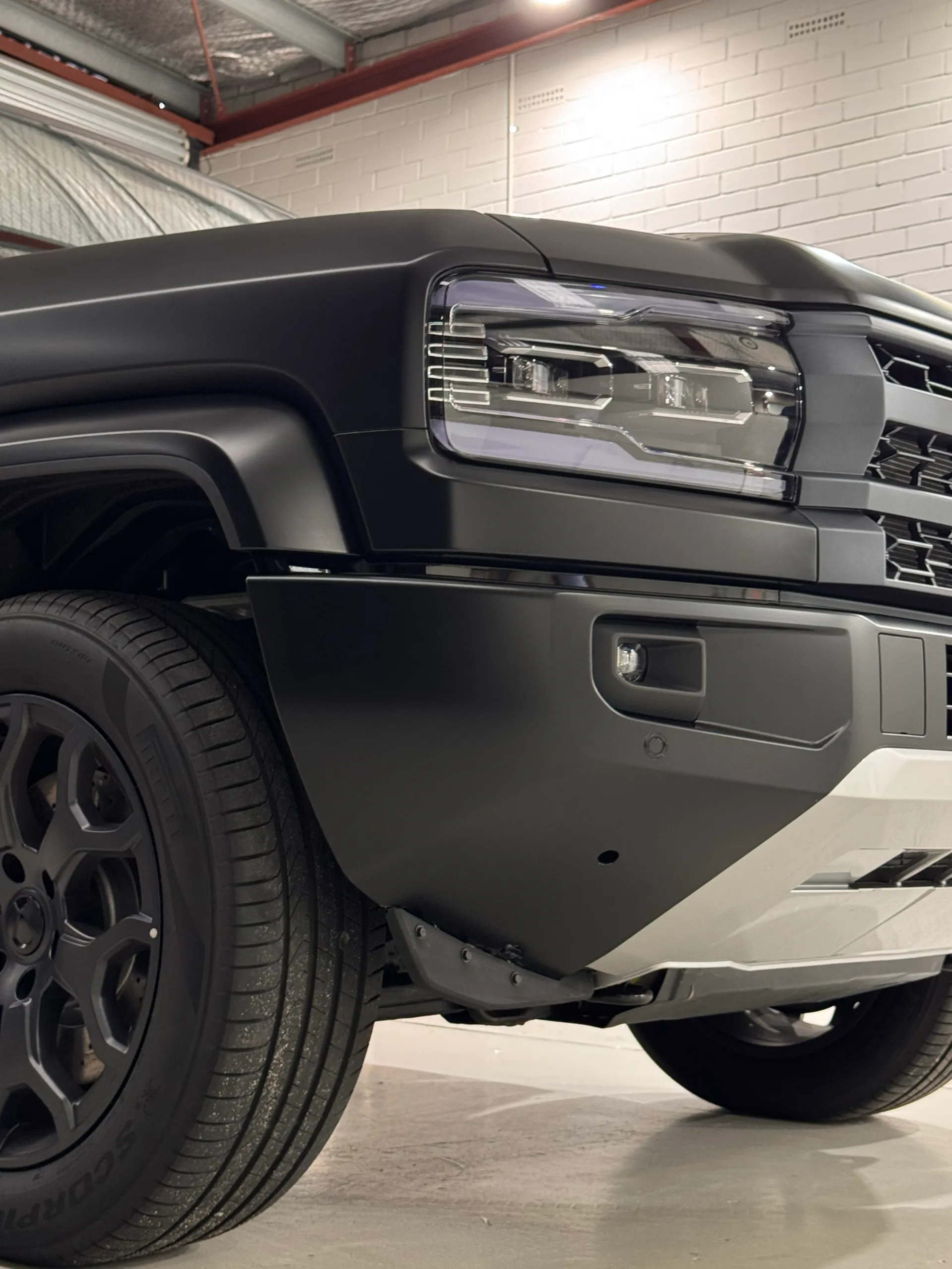 Low front-corner view of the satin grey Denza B5 headlight and wheel