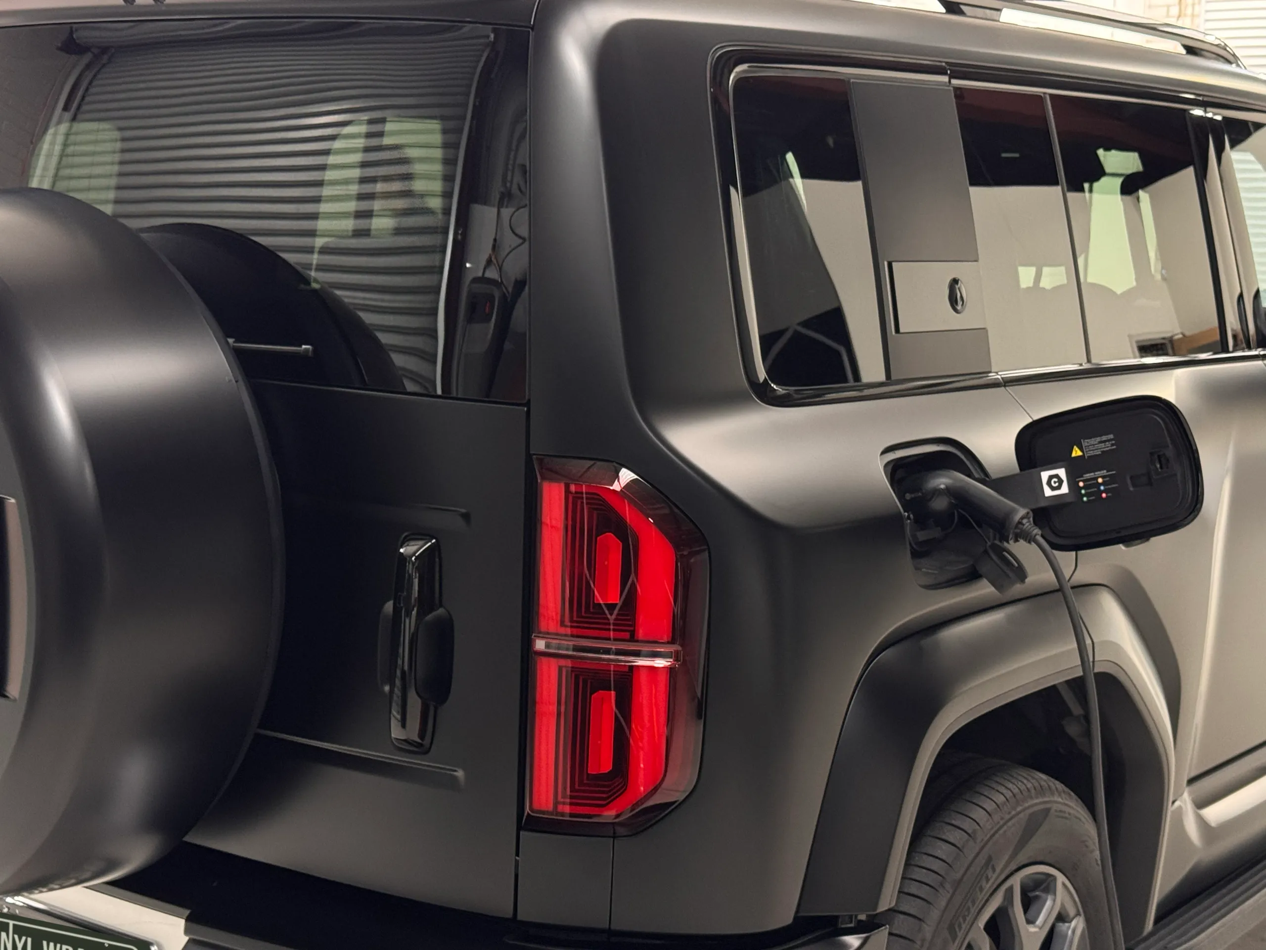 Charging cable connected beside the Denza B5 rear light and spare wheel cover