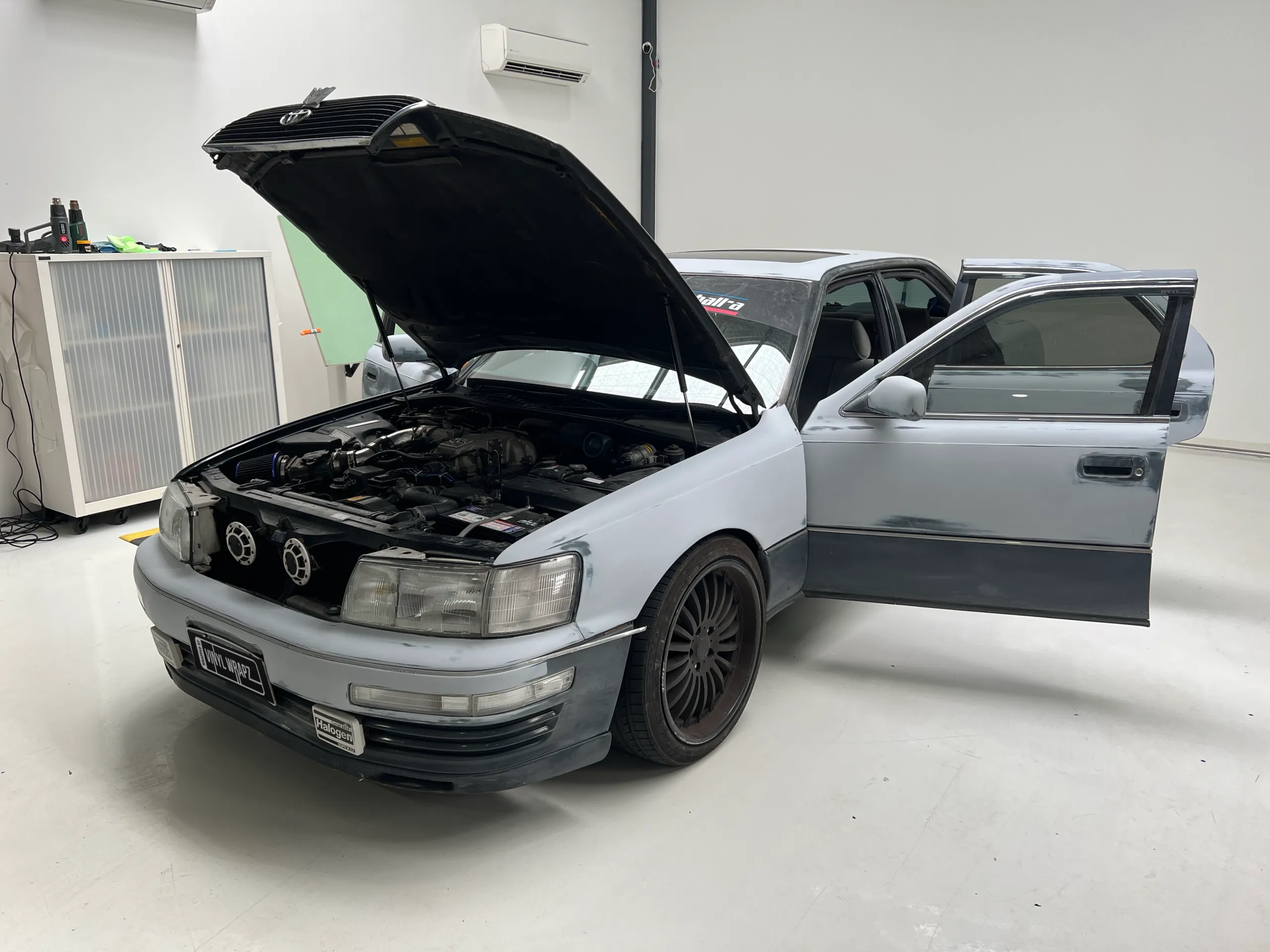 Plain Toyota Celsior with its bonnet open before wrapping