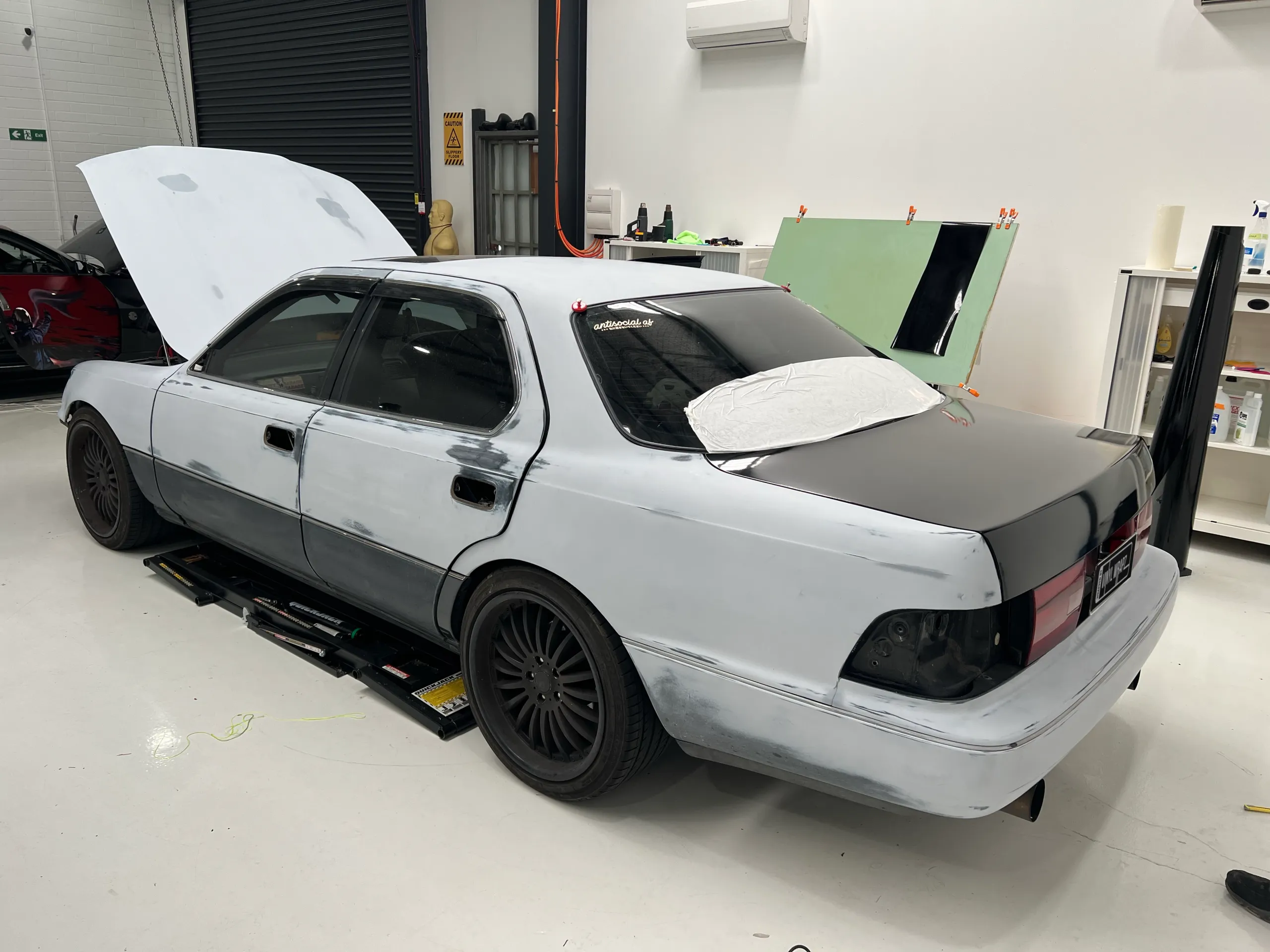 Unwrapped Toyota Celsior with its boot open in the workshop