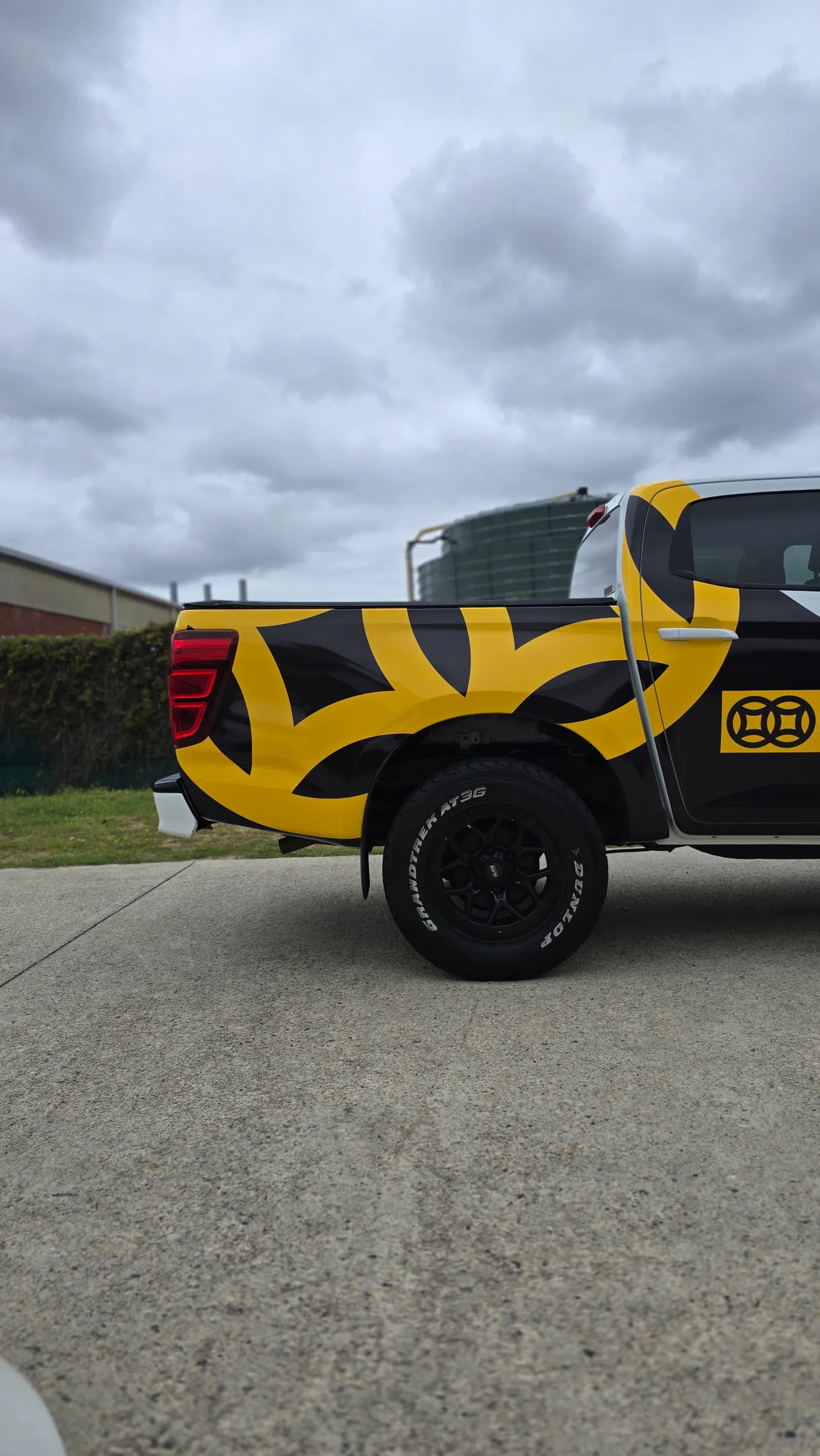 Black and yellow graphics across the Mazda BT-50 tray side outdoors