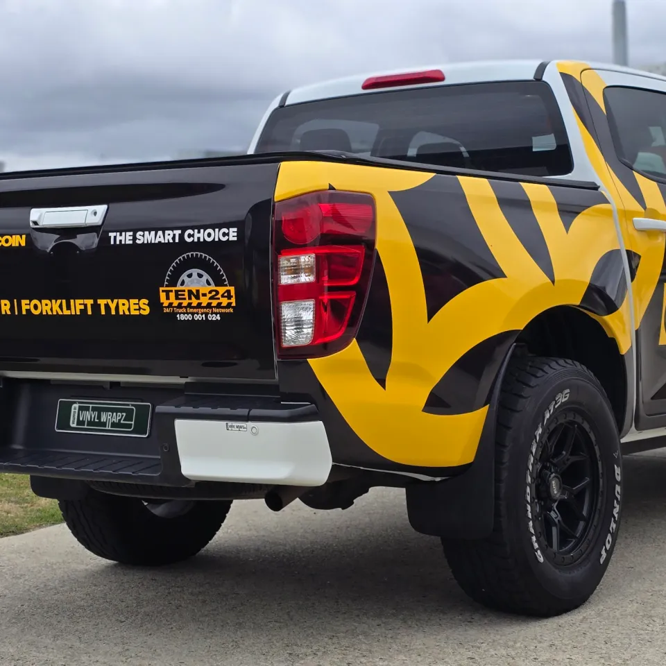 White Mazda BT-50 with black and yellow Double Coin graphics outside the workshop