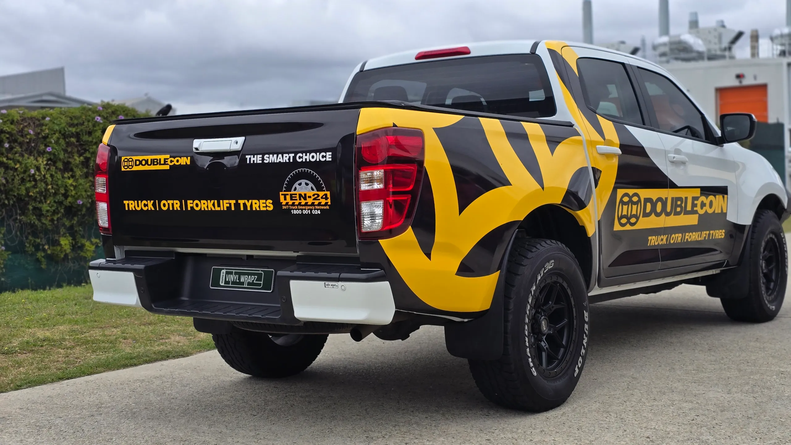 White Mazda BT-50 with black and yellow Double Coin graphics outside the workshop
