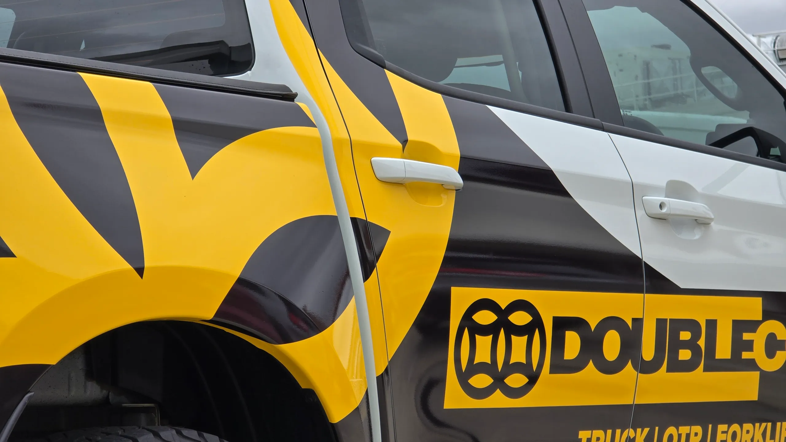 Double Coin door branding and black and yellow graphics across the Mazda BT-50 rear quarter