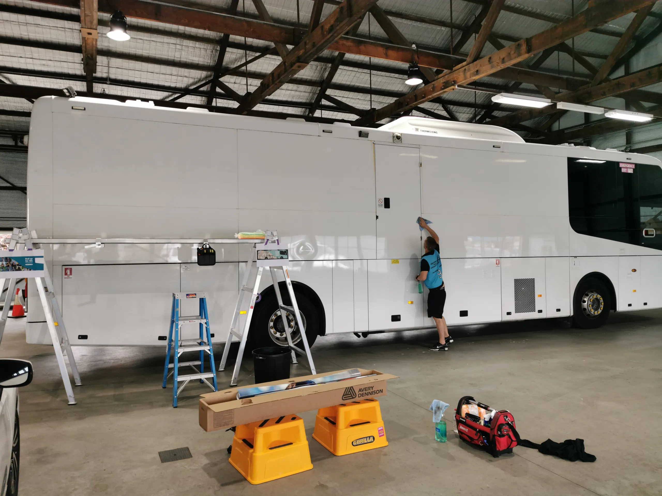 Installer preparing the white coach body in the workshop