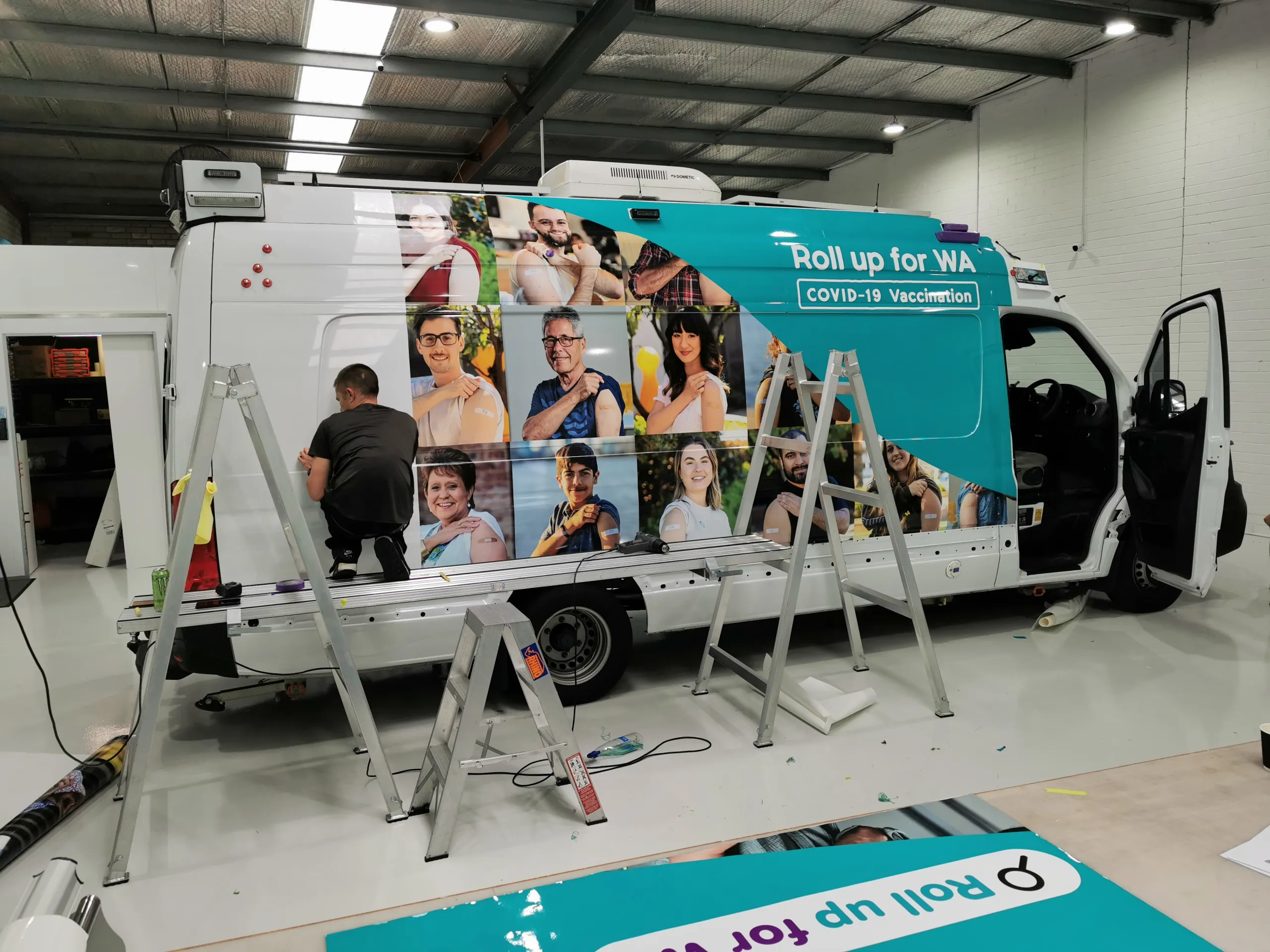 Side view of an installer fitting vaccination graphics