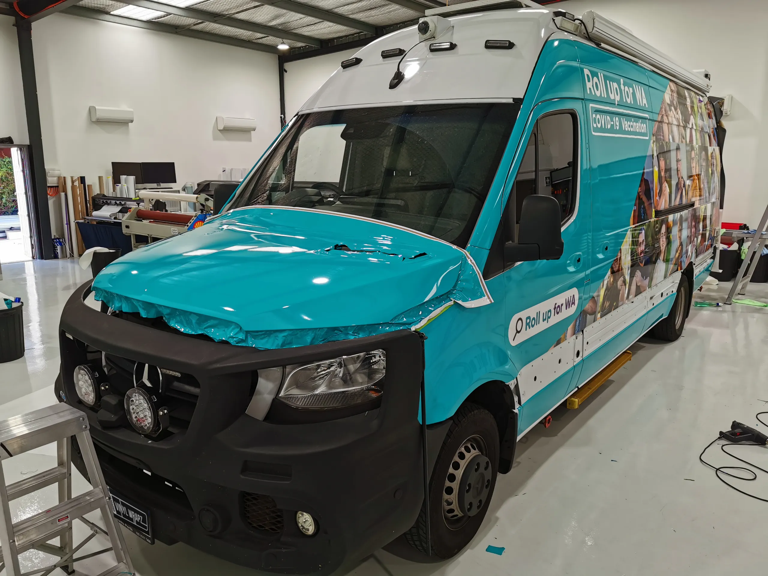 Sprinter with bonnet film partly fitted in the workshop