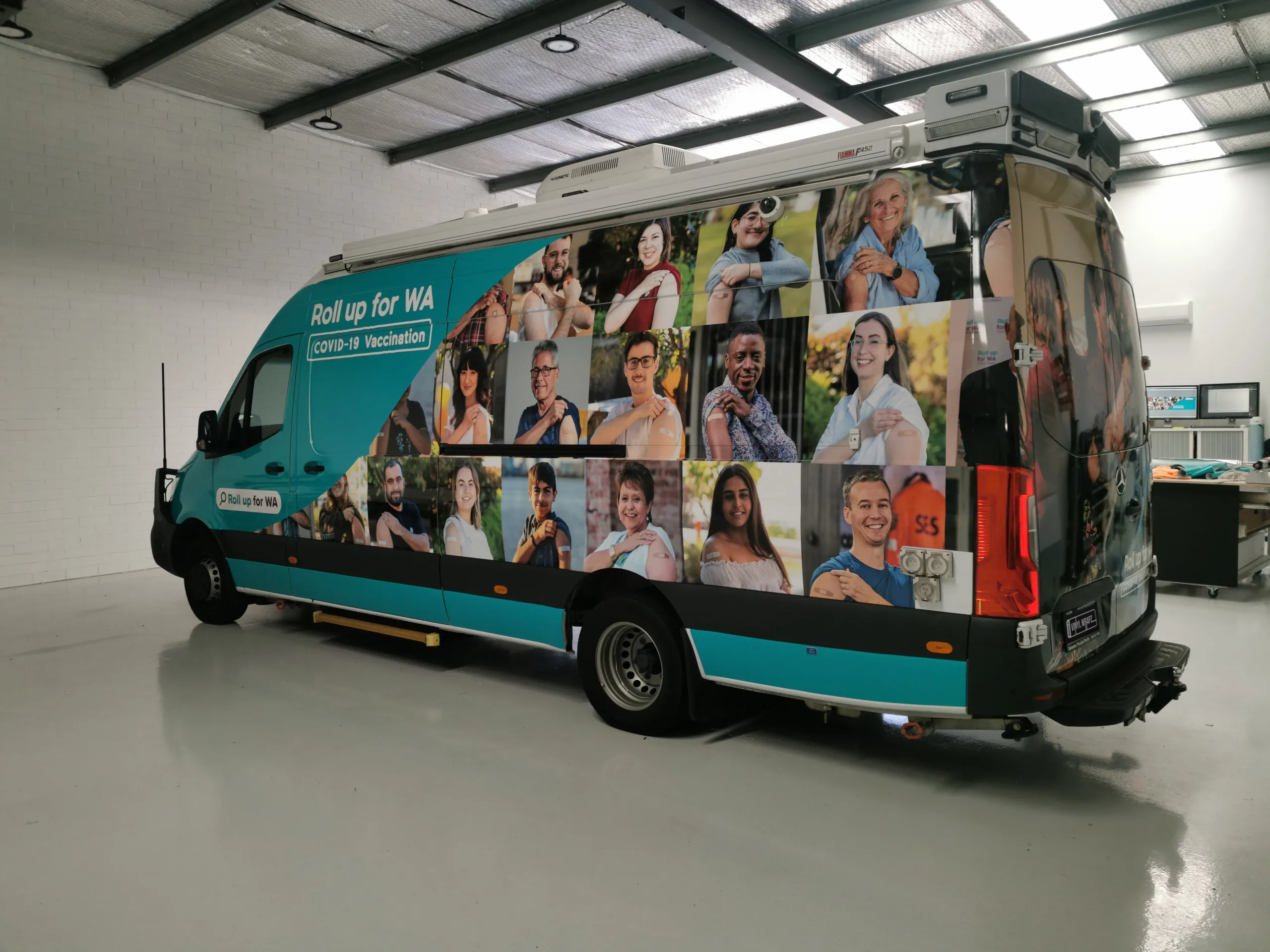 Opposite rear-quarter view of the branded vaccination van