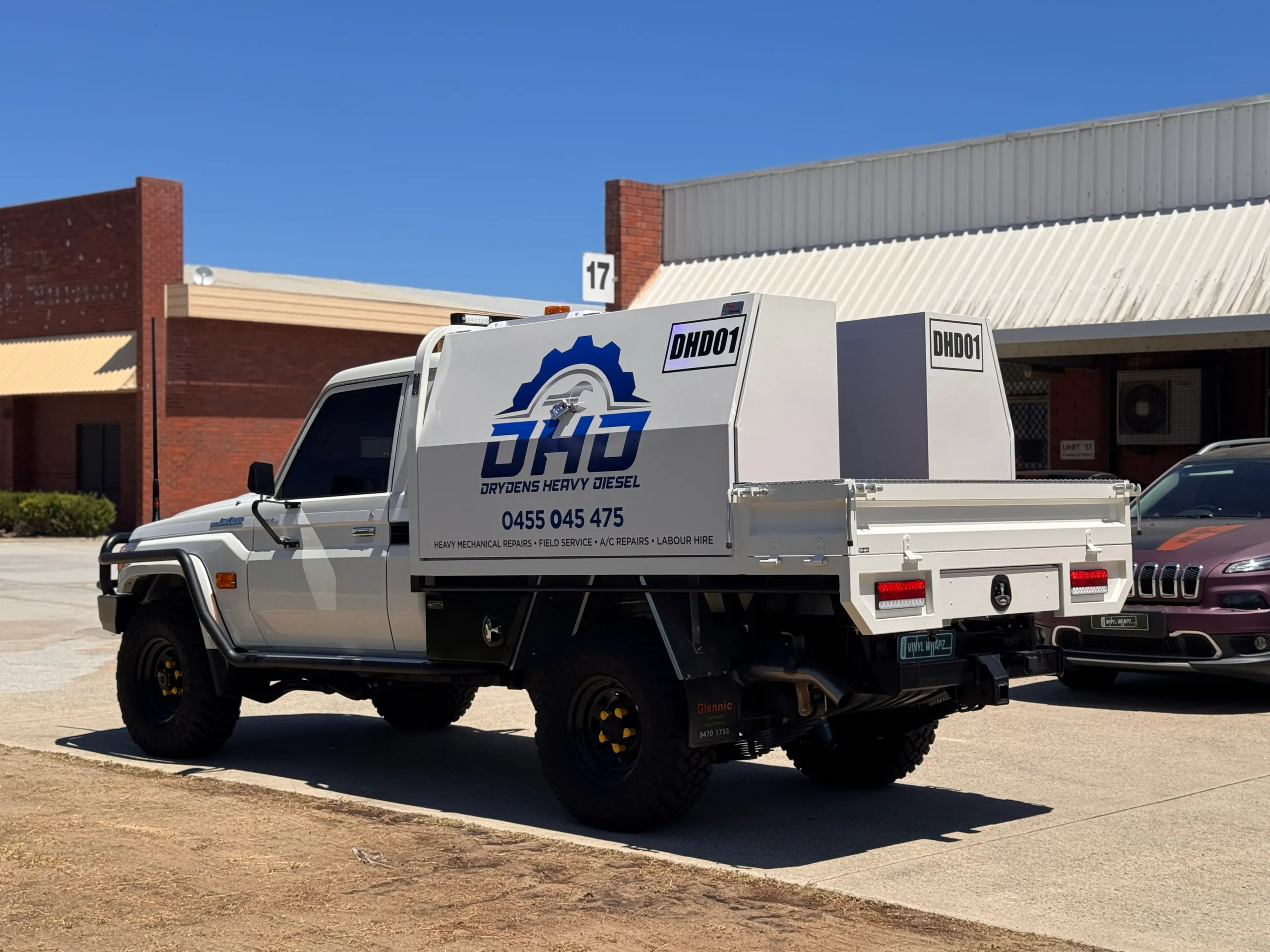 White LandCruiser with Drydens Heavy Diesel toolbox graphics outside the workshop