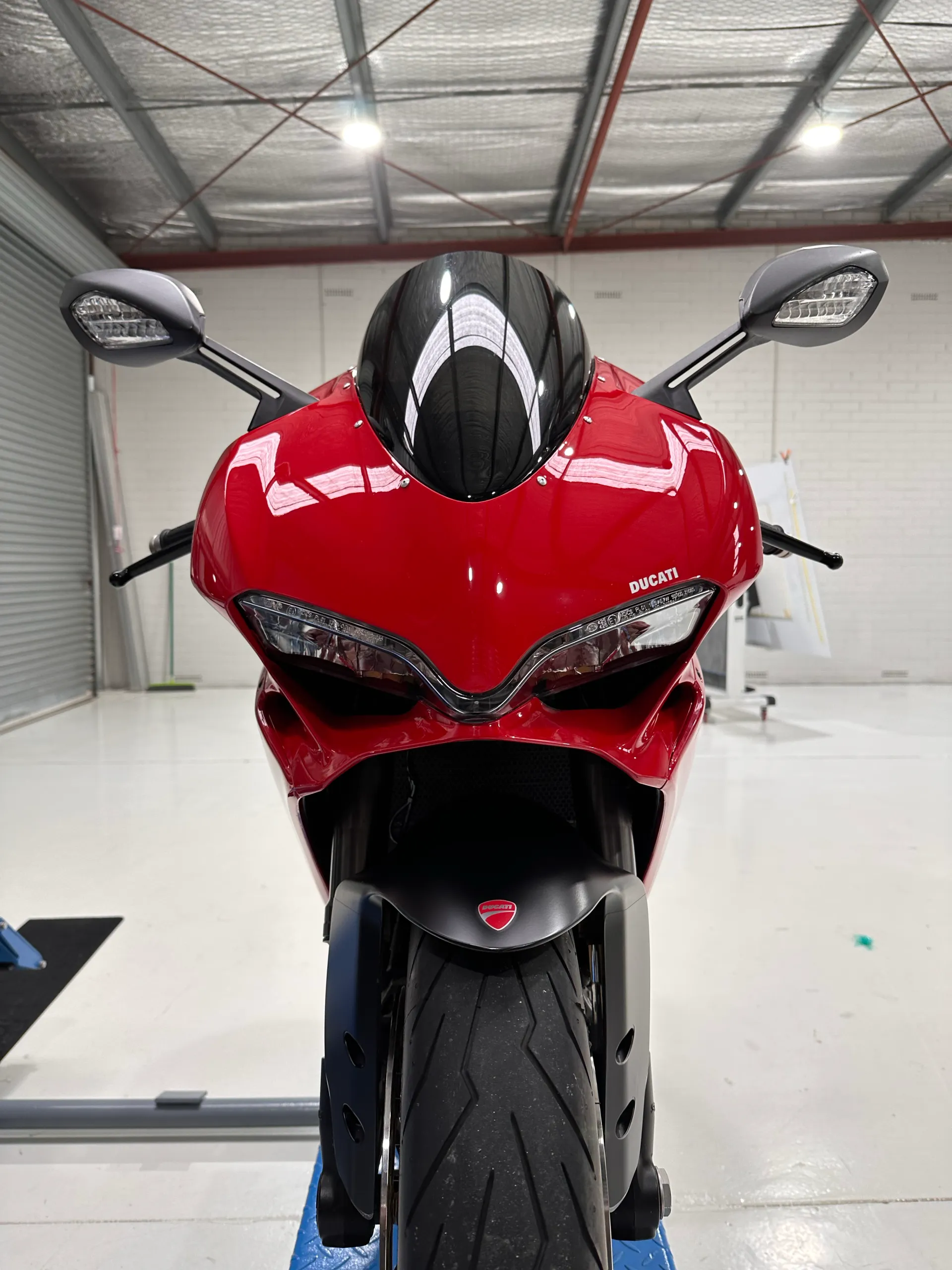 Front view of a red Ducati 959 Panigale on a workshop lift