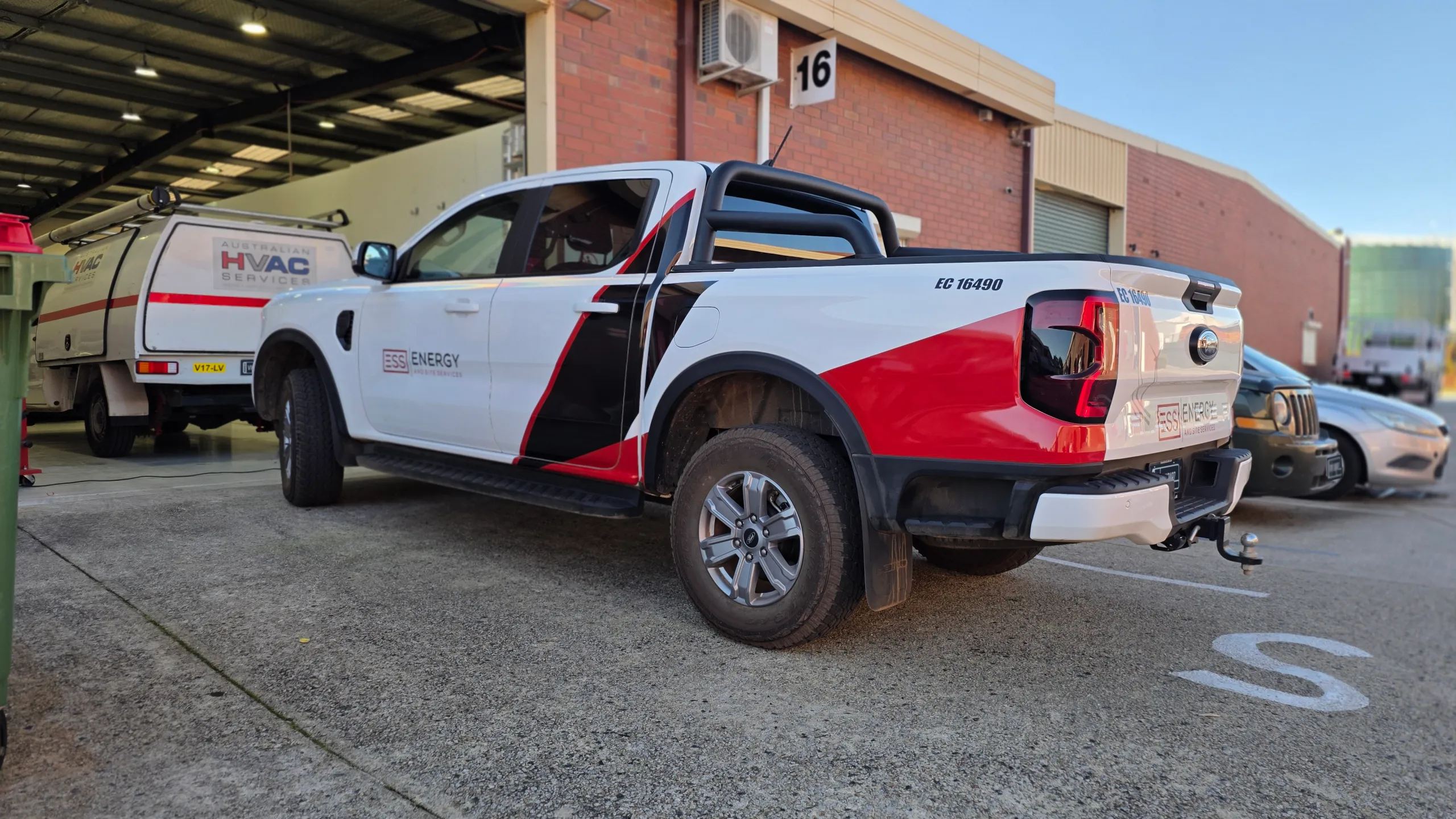 Rear-quarter view of a white Ford Ranger with ESS fleet graphics