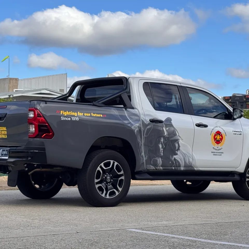 Toyota Hilux with Firefighters Union partial-wrap graphics outside the workshop