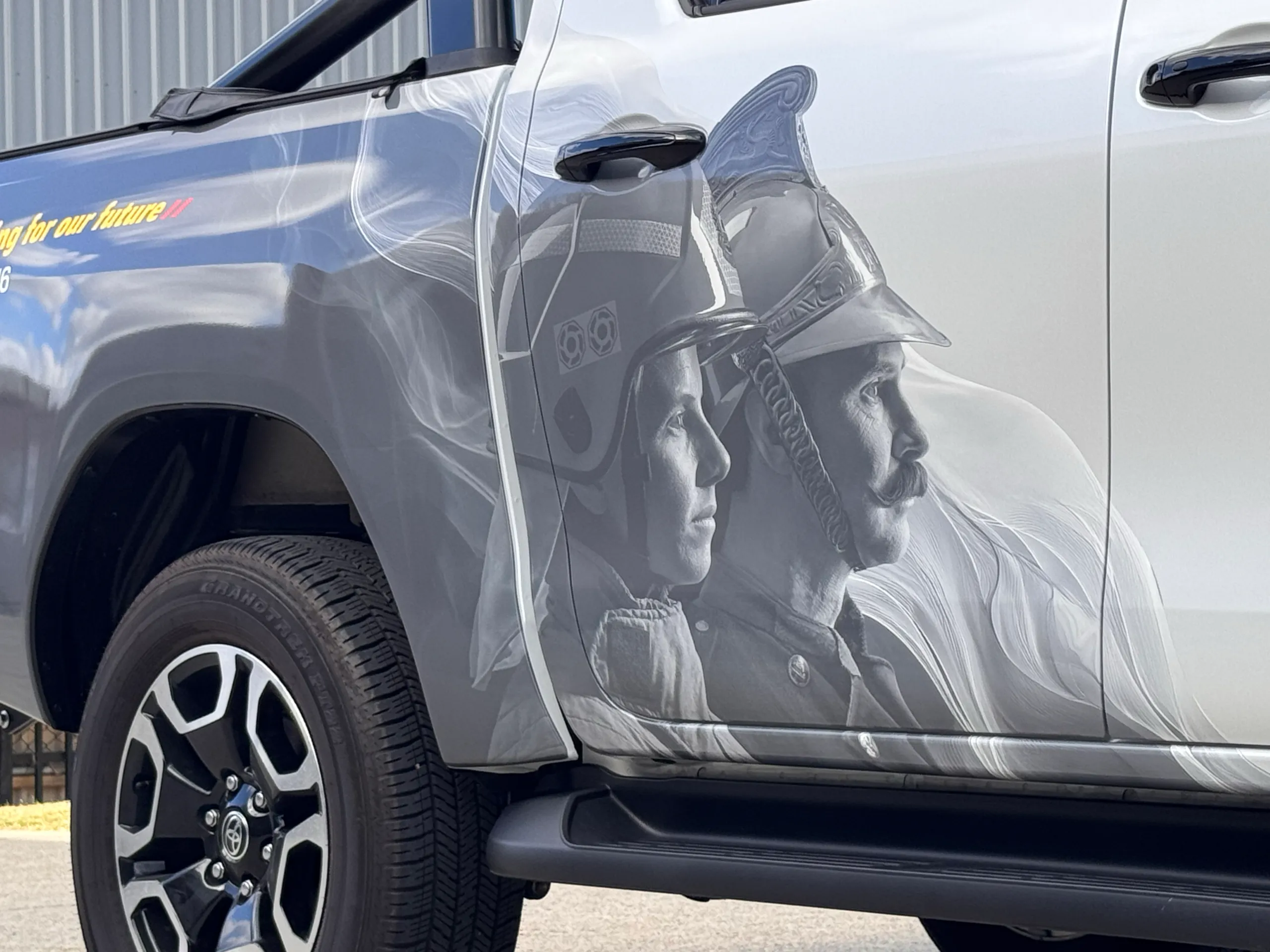 Grey firefighter artwork across the Hilux rear door and tray side