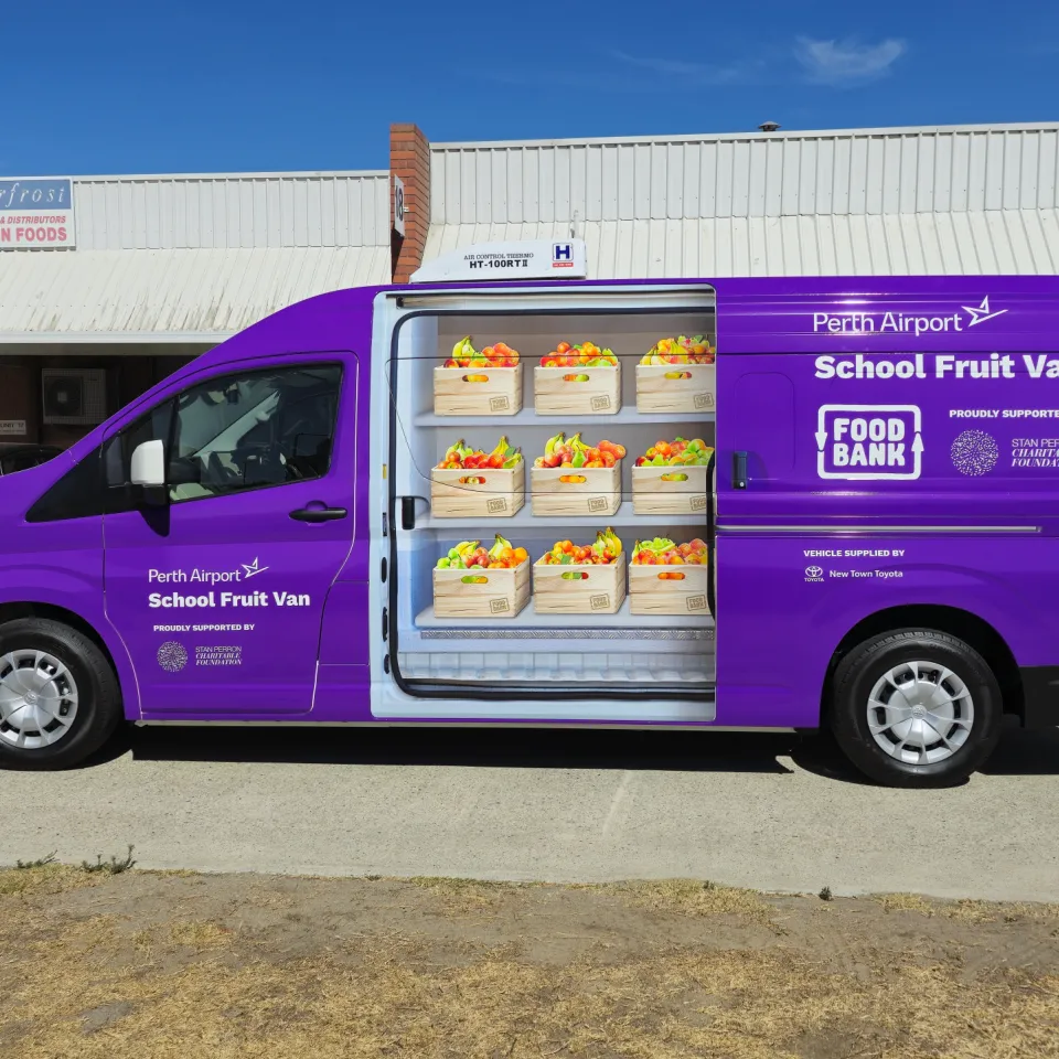 Toyota Hiace in purple Foodbank School Fruit Van graphics with printed fruit crates along its side