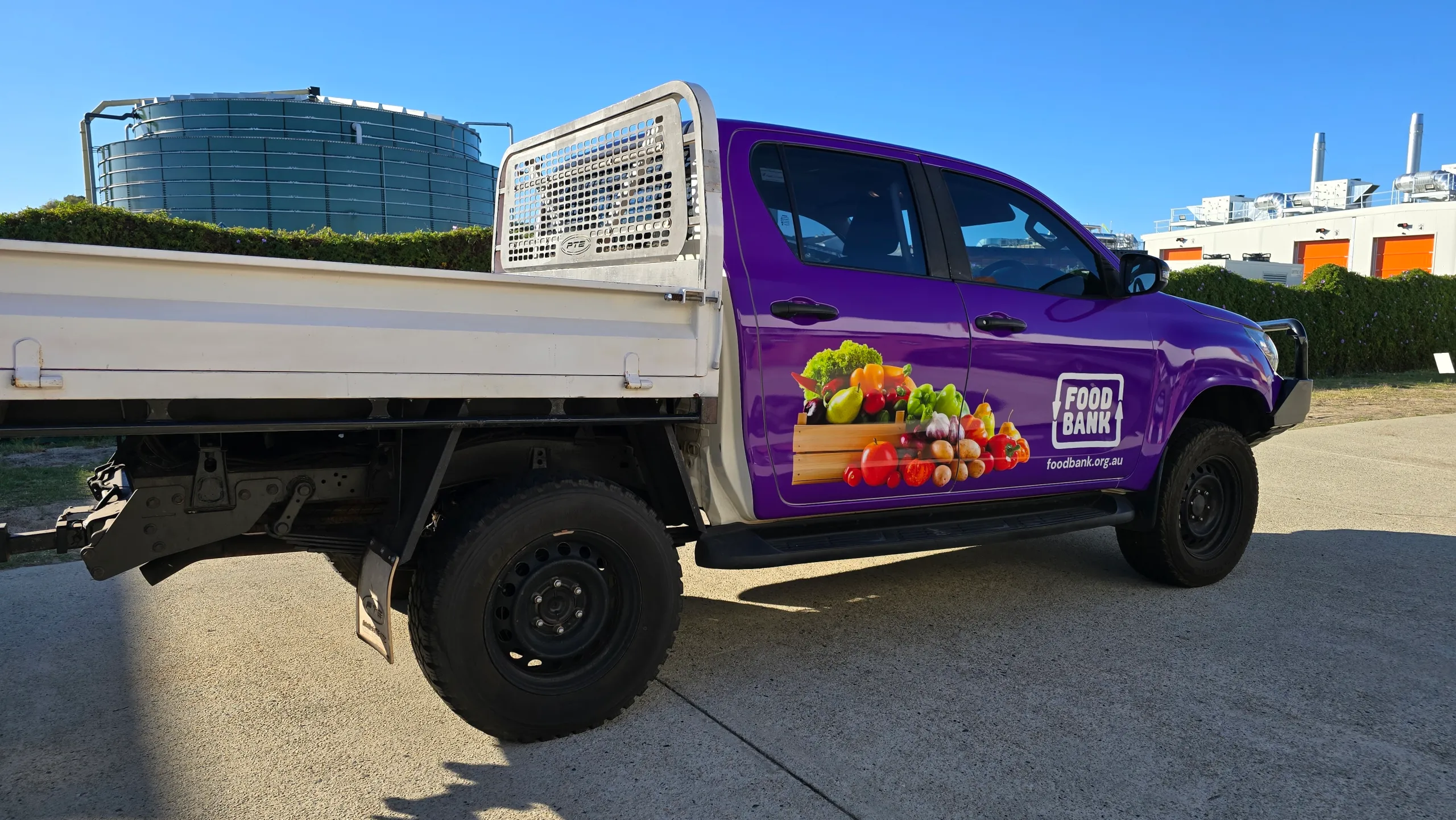 Purple Foodbank Toyota Hilux cab beside its white aluminium tray