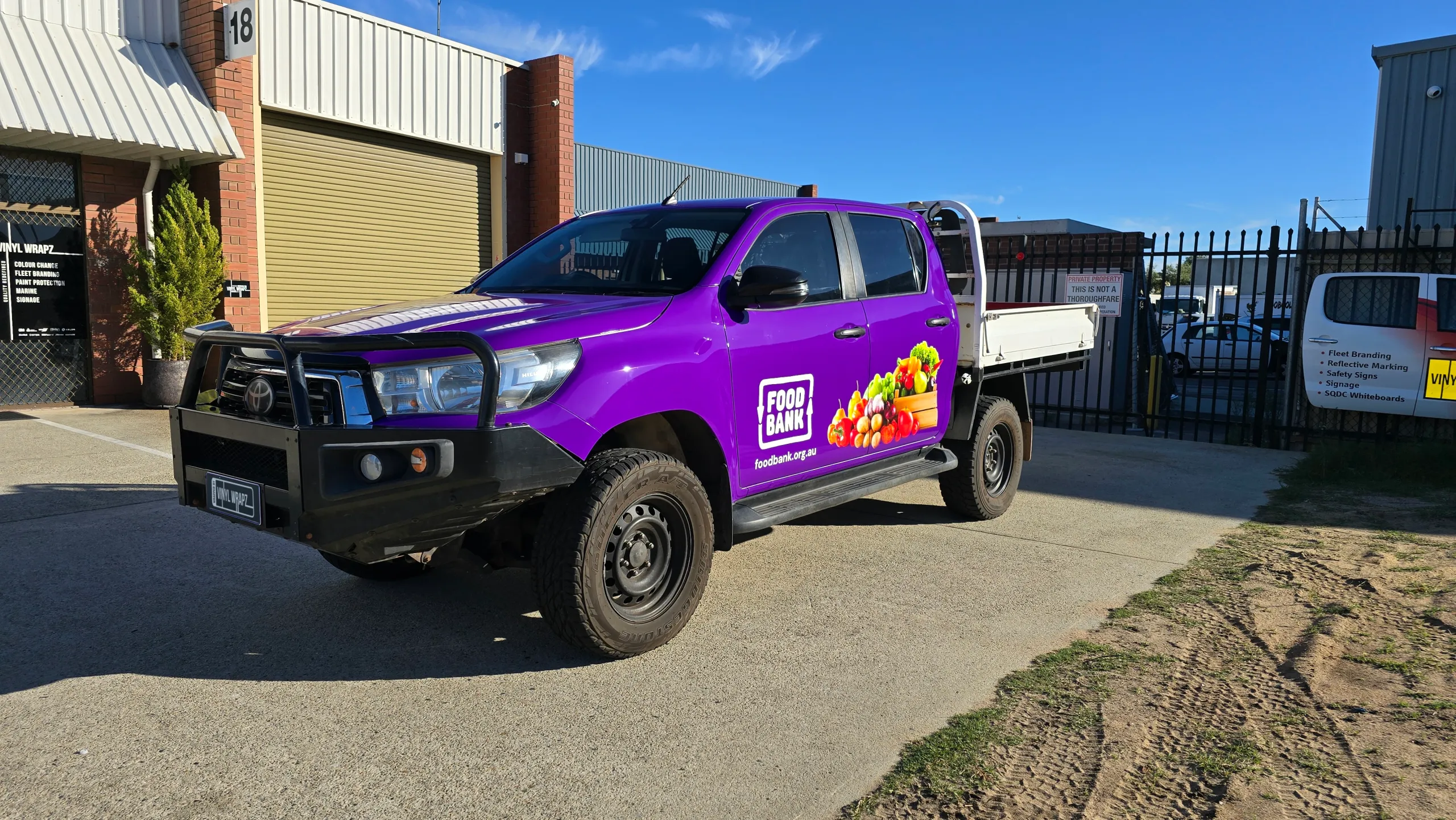 Toyota Hilux with purple Foodbank graphics and a black bull bar outdoors
