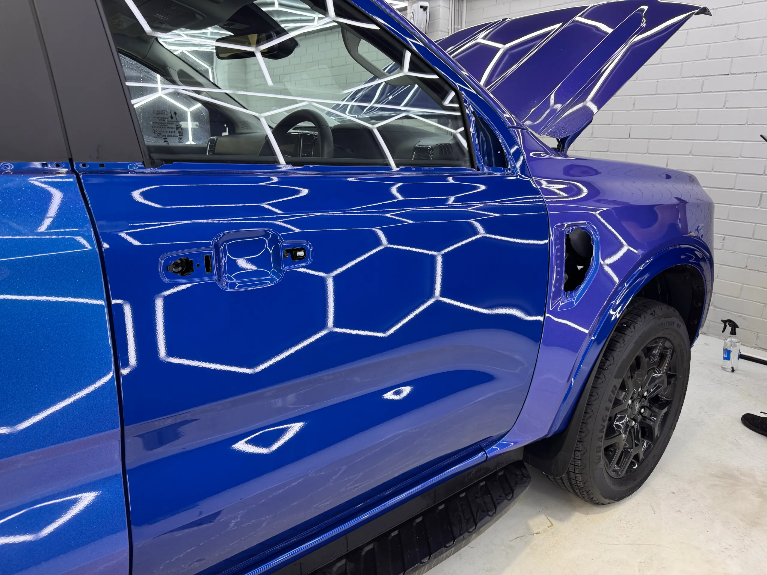 Blue Ford Everest front door with handles and mirror removed during wrapping