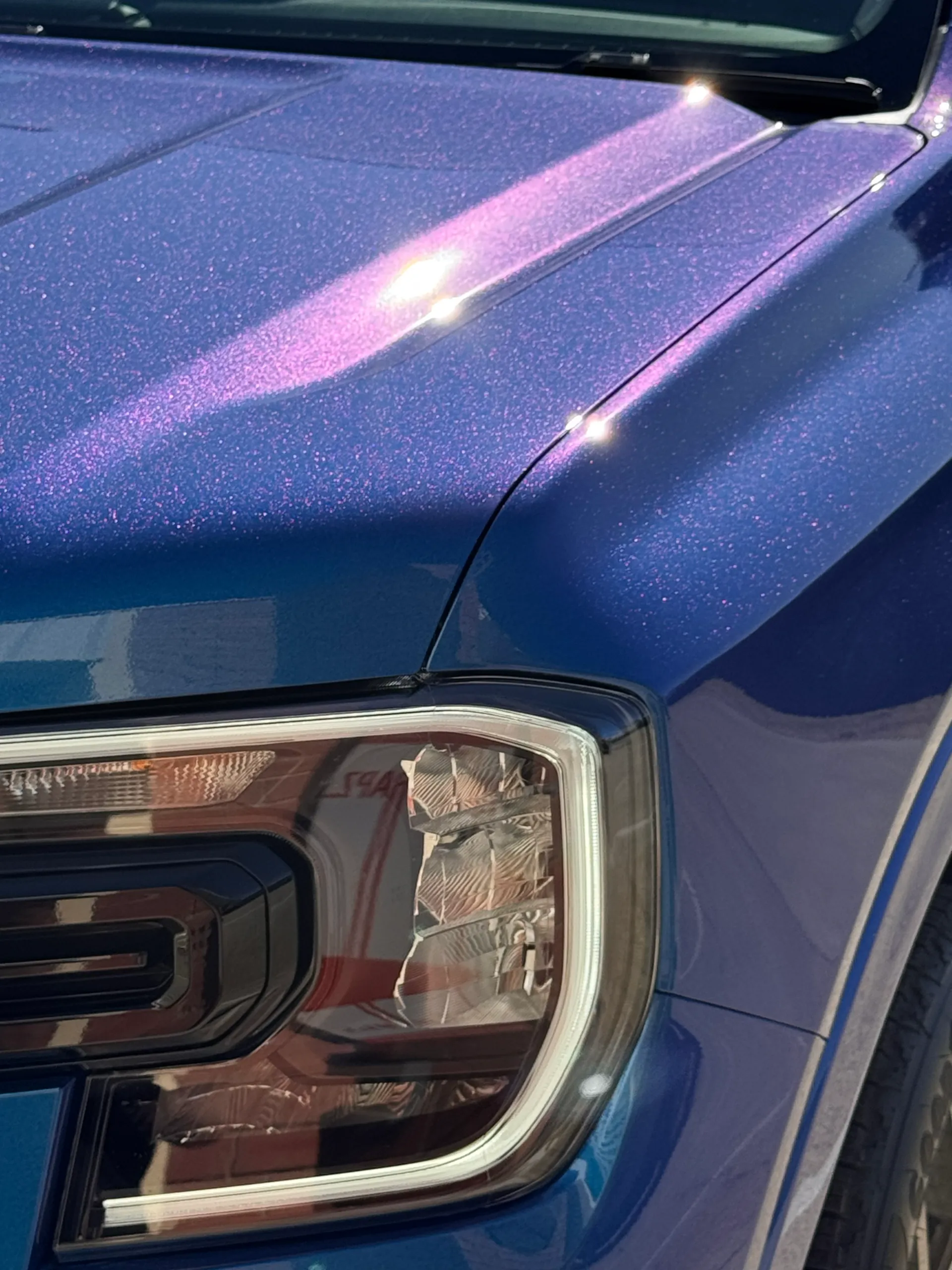 Blue and purple iridescent finish around the Ford Everest headlight and bonnet
