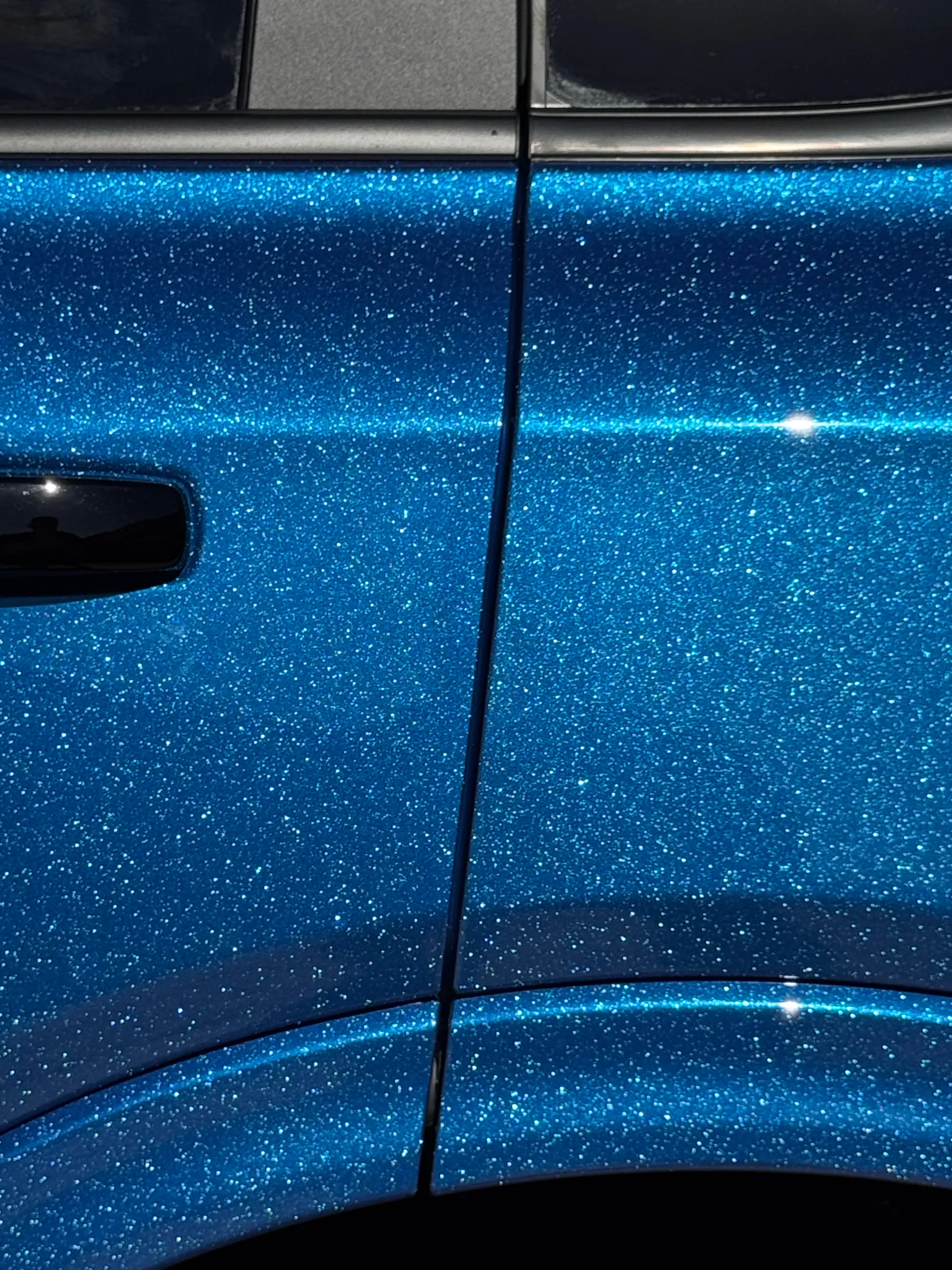 Blue iridescent finish across the Ford Everest door panels in direct sunlight