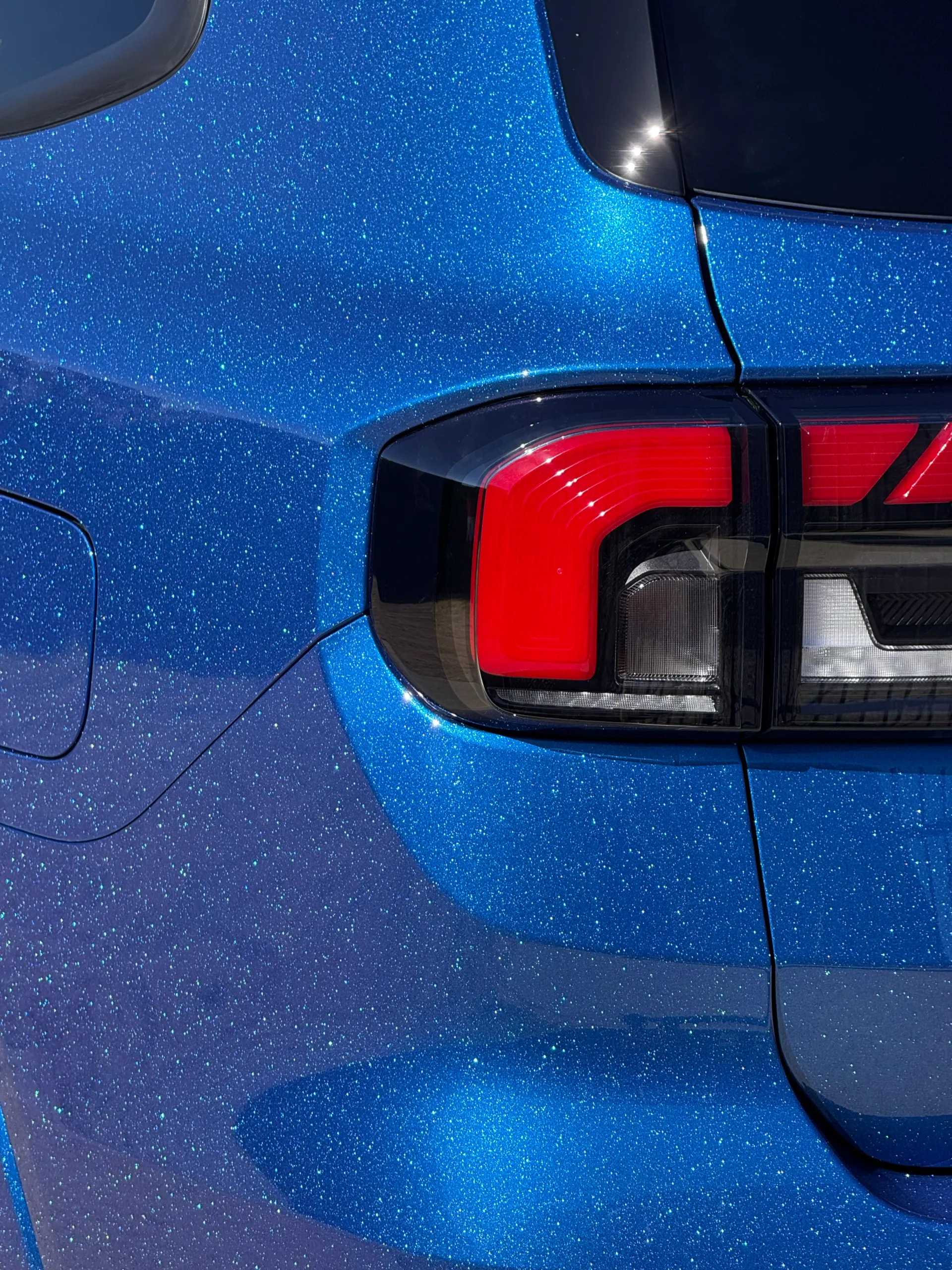 Fine sparkle across the blue Ford Everest rear pillar and rear light surround