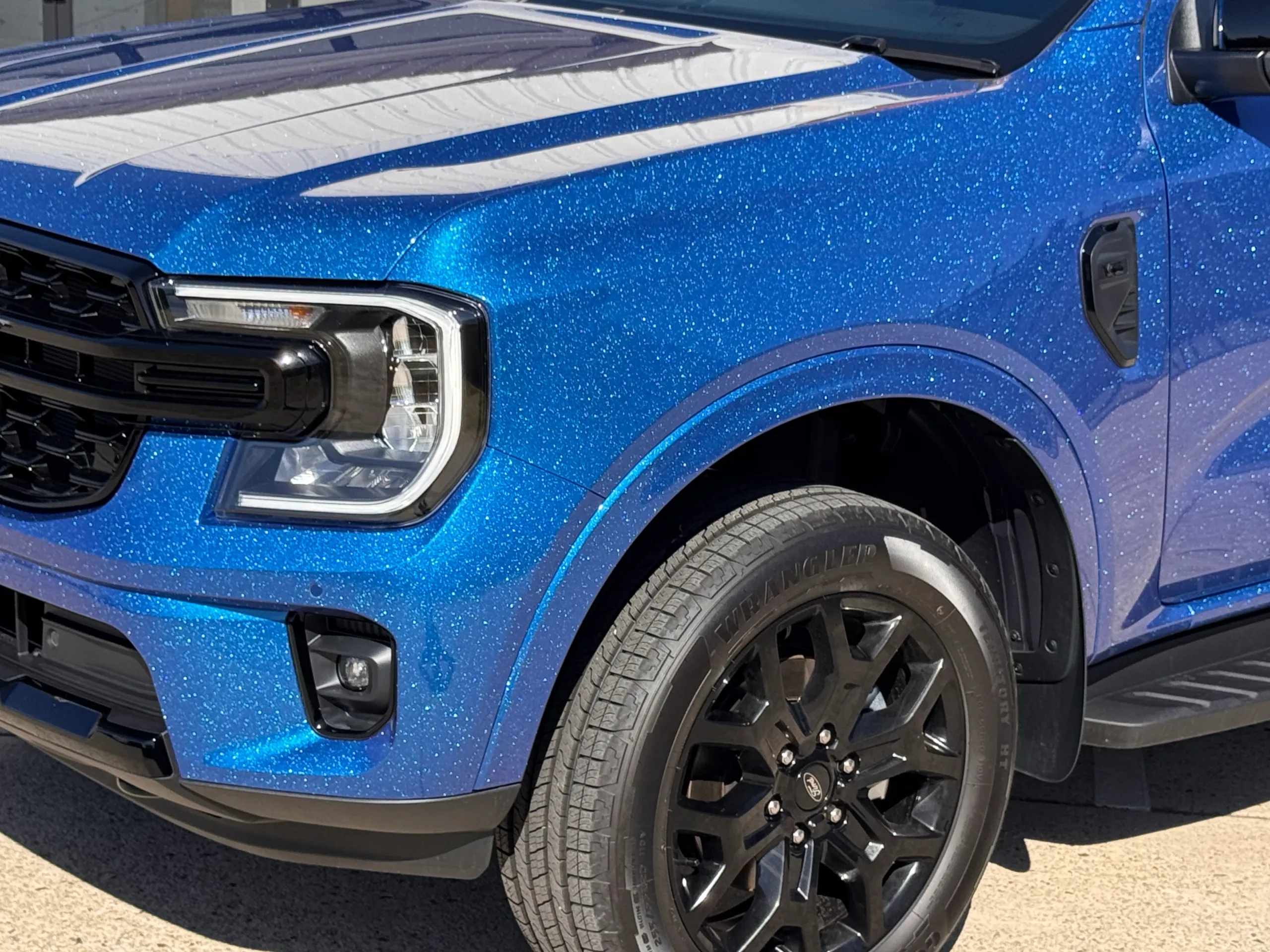 Gloss blue Ford Everest front guard, bonnet and black wheel outdoors