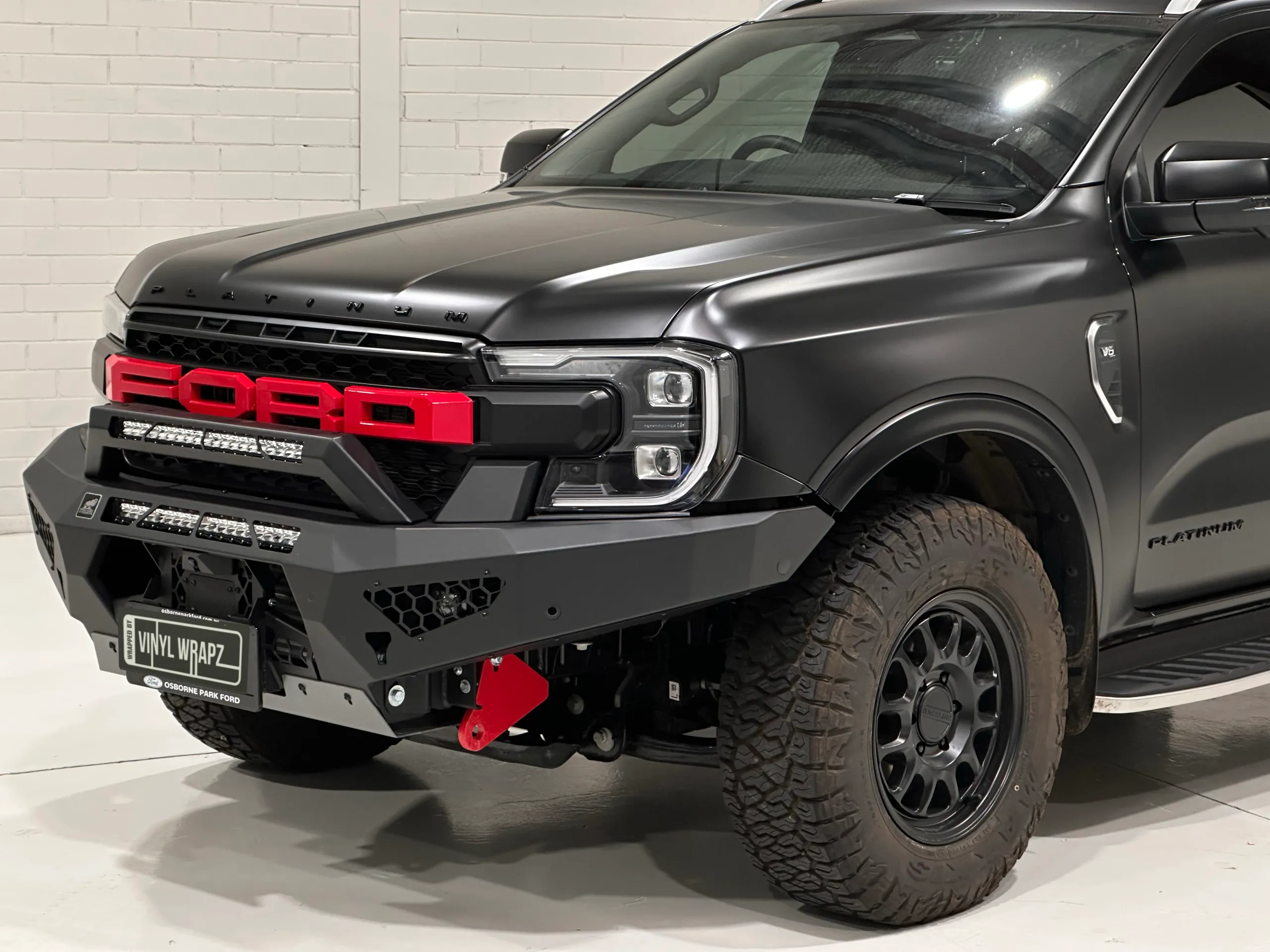 Satin black Ford Everest Platinum front corner with red Ford grille lettering and a black bullbar
