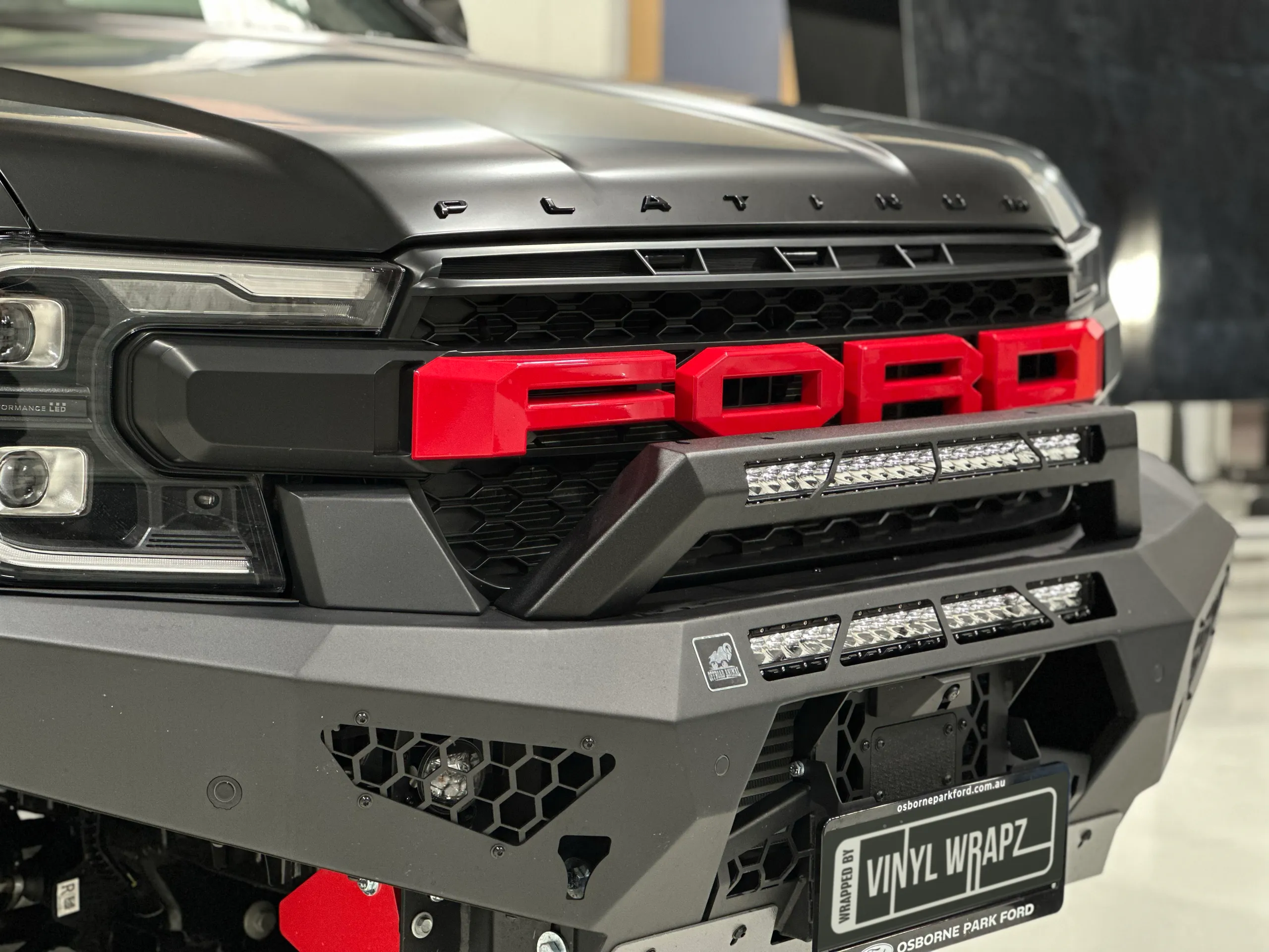 Ford Everest front grille, black bullbar and driving lights beneath its satin bonnet